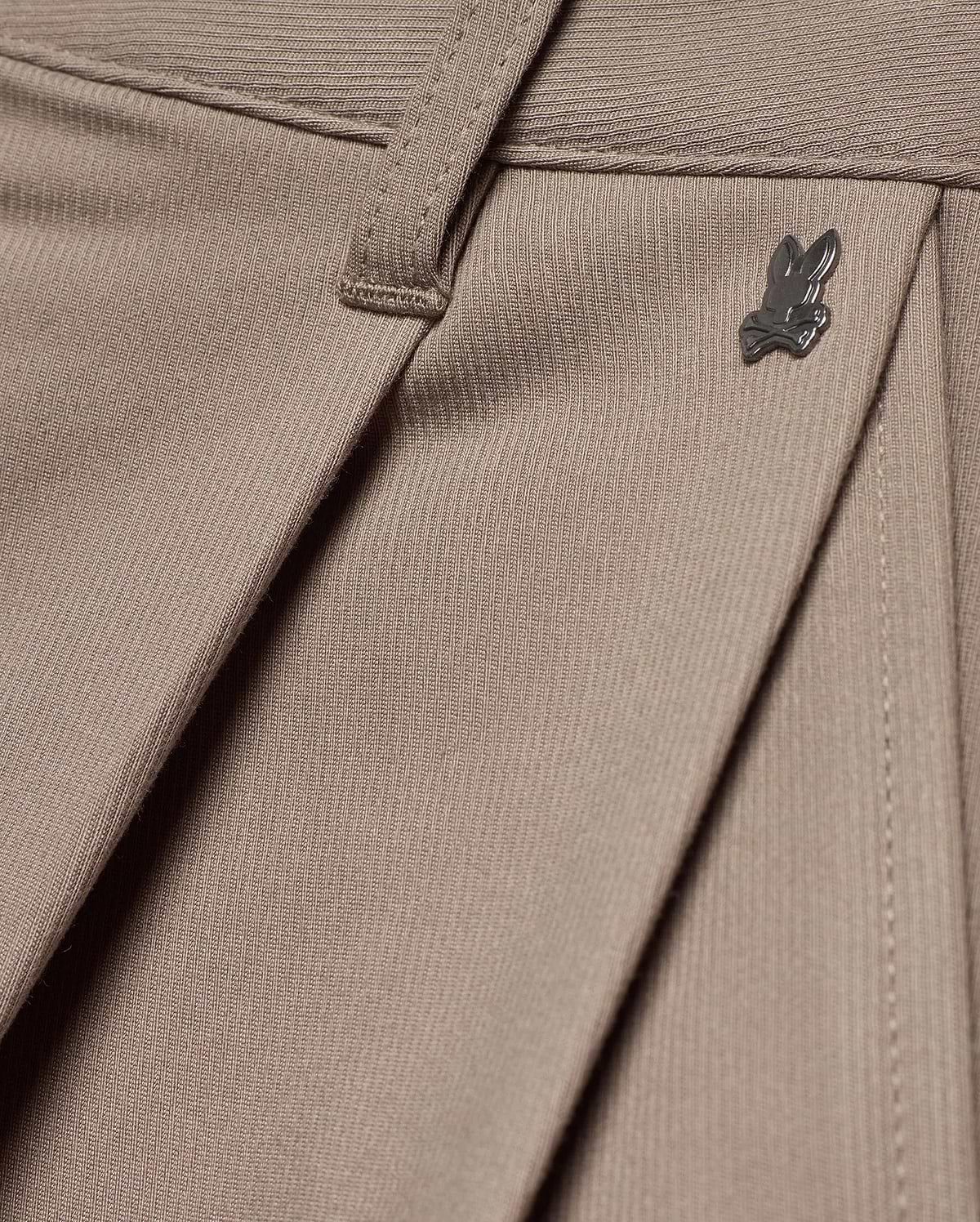 MEN'S WAYDE WIDE-LEG PLEATED PANTS in taupe, featuring a subtle ribbed knit texture, front pleats, and a small dark metal Psycho Bunny skull logo near the waistband. (6)