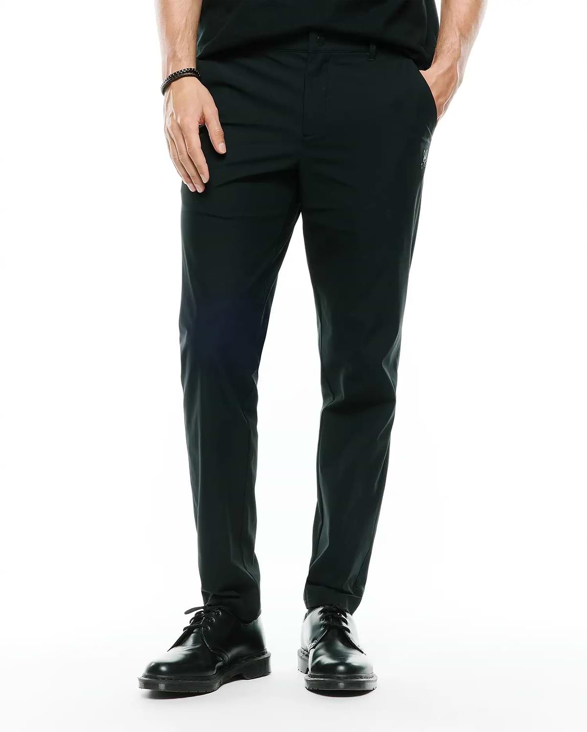 Mens Edward 10k Tapered Pant in dark green, featuring a slim tapered fit and smooth performance fabric, with a small embroidered Psycho Bunny skull logo on the upper right thigh.