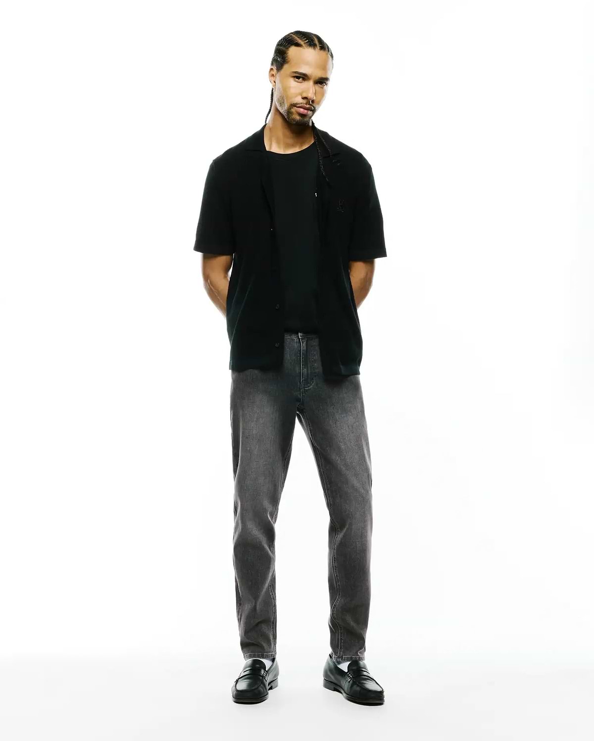 Black jersey t-shirt, black relaxed short-sleeve shirt with small embroidered Psycho Bunny skull on left chest, and Mens Emerson Denim Pant in dark grey wash.