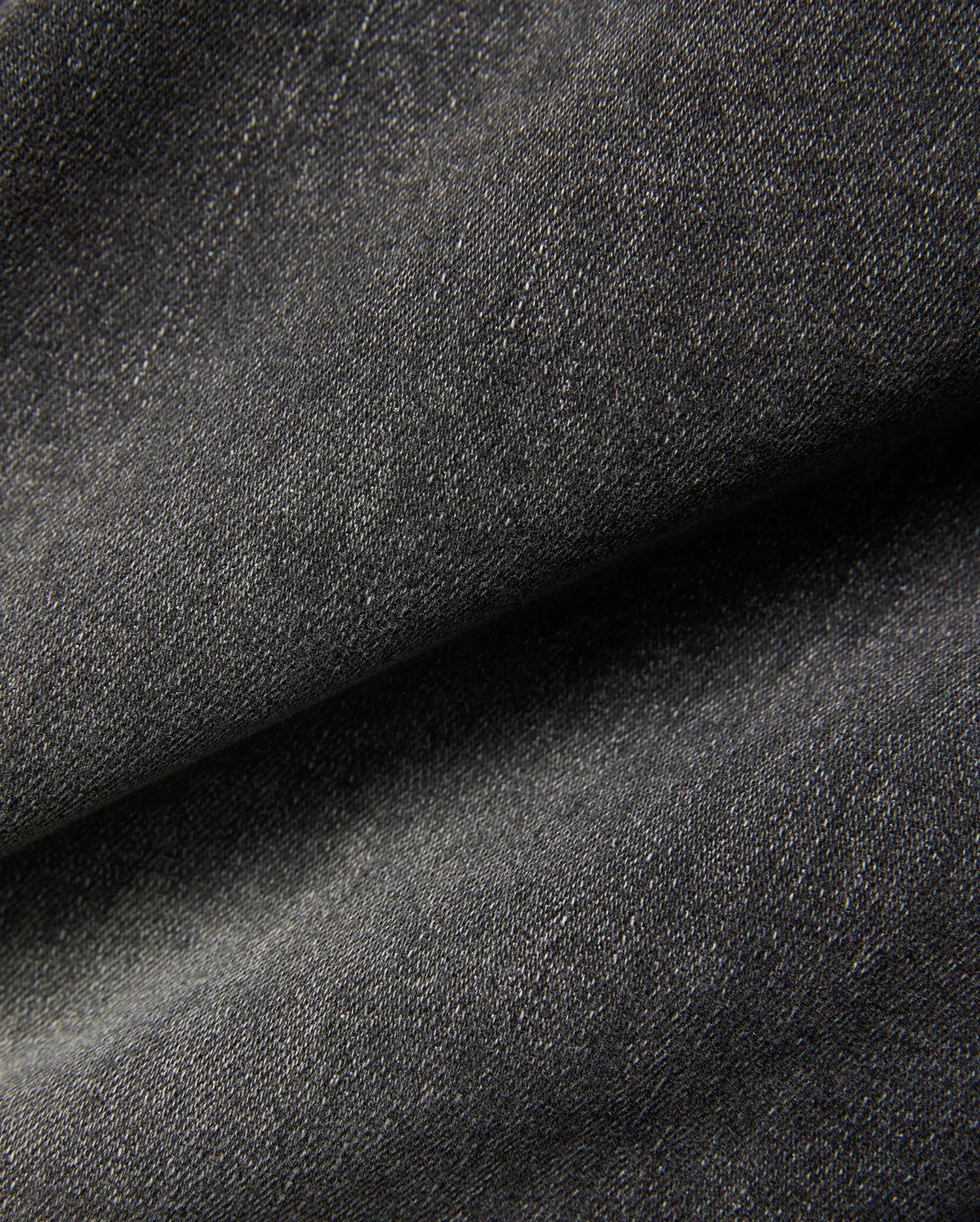 Mens Emerson Denim Pant featuring a dark charcoal grey denim fabric with a visible twill weave and subtle light flecks, creating a textured, washed appearance.