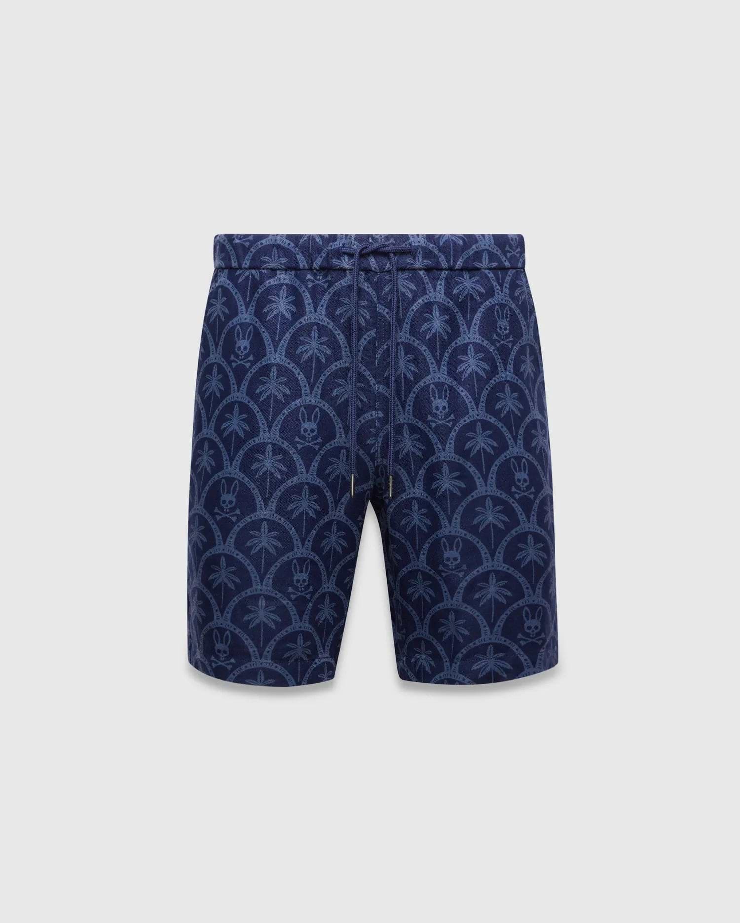 Mens Brad Linen Short 8 1/2, navy blue linen relaxed fit shorts with an all-over lighter blue pattern of palm trees and Psycho Bunny skull logos within scalloped arches, featuring a drawstring waist.