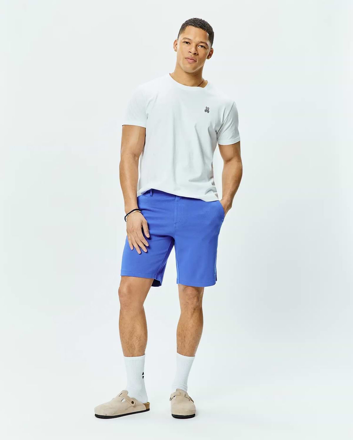 White classic fit jersey t-shirt featuring a small embroidered multi-color Psycho Bunny skull logo on the left chest, paired with vibrant blue MENS SHIRO TWILL SHORT.