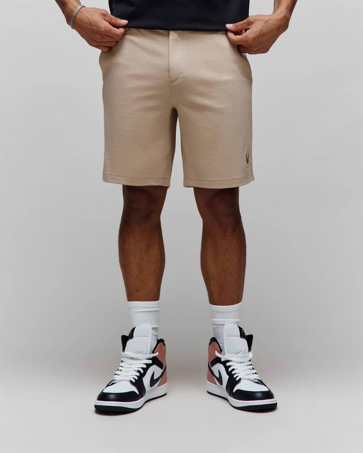 Mens Shiro Twill Short, a classic fit beige twill short featuring a subtle texture and a small embroidered Psycho Bunny skull logo on the lower left leg.