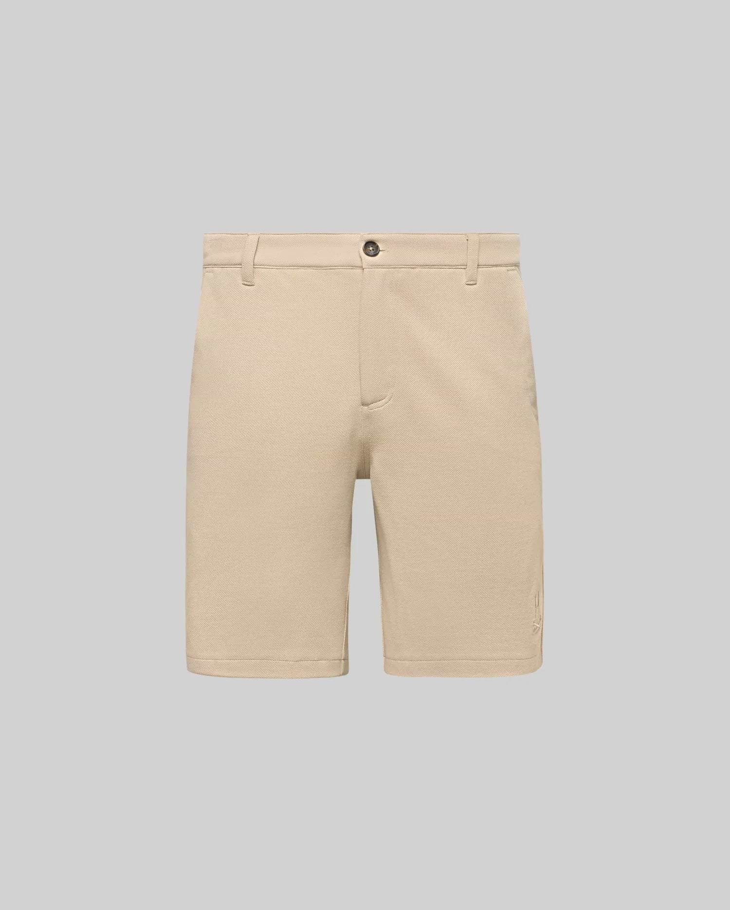 Mens Shiro Twill Short in beige, featuring a classic fit, visible twill texture, button closure, and a small embroidered Psycho Bunny skull logo on the lower left leg.