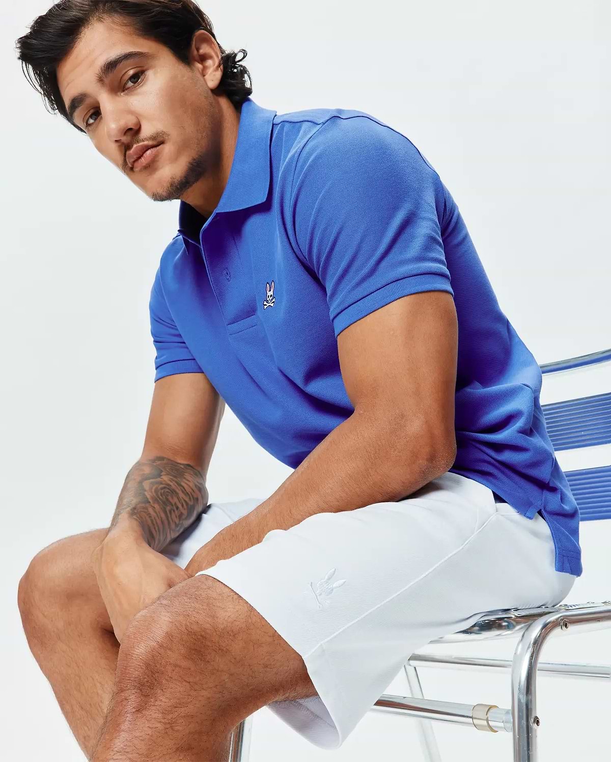 Royal blue pique polo with small embroidered Psycho Bunny skull logo on left chest. White Mens Shiro Twill Short features an embroidered bunny logo on the left thigh.