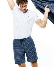 White jersey t-shirt with small embroidered Psycho Bunny skull logo on left chest, paired with Mens Erik Raised Check Short in navy and light blue, featuring a textured pattern and drawstring waist.