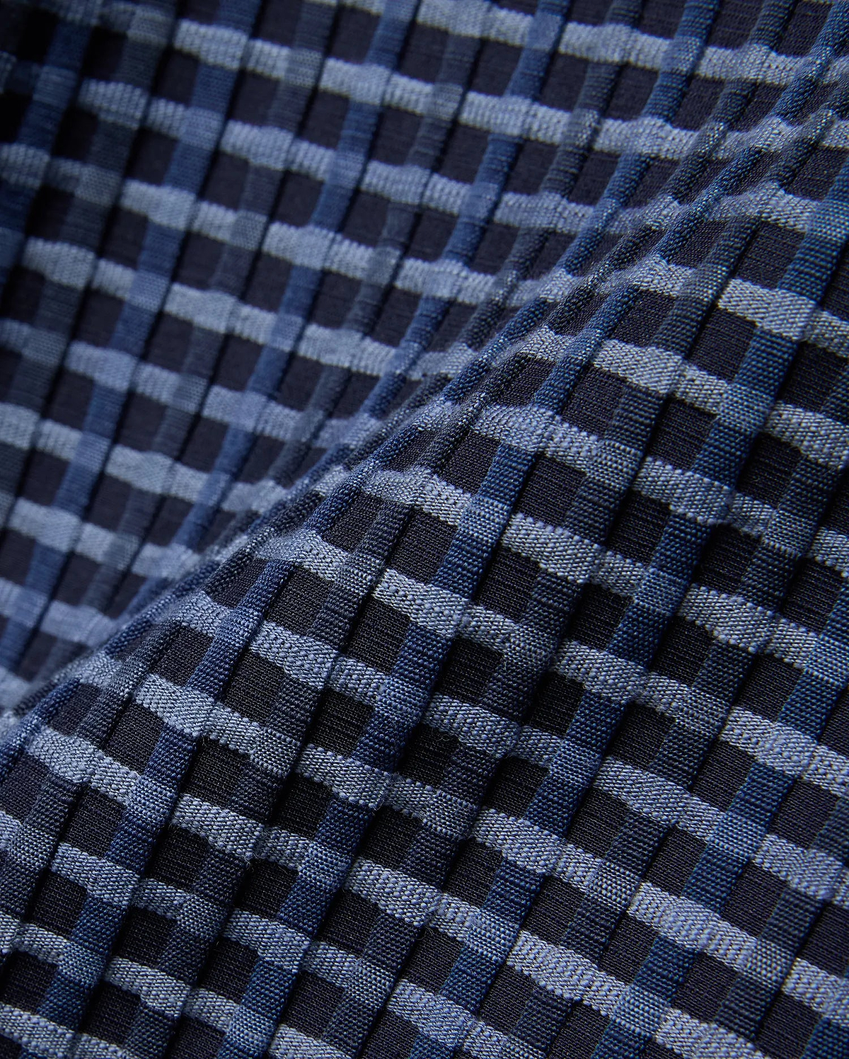 Mens Erik Raised Check Short featuring a textured, raised check pattern in varying shades of deep navy, medium blue, and light blue, creating a dynamic woven effect.