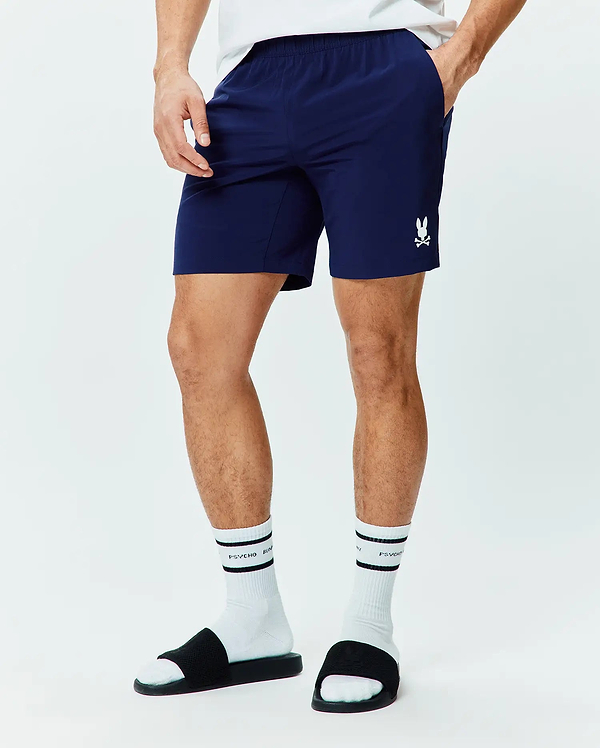 Mens Blaze Sport Short, navy blue classic fit shorts in smooth performance fabric with an elastic waistband, side pockets, and a small white embroidered Psycho Bunny skull logo on the left leg.