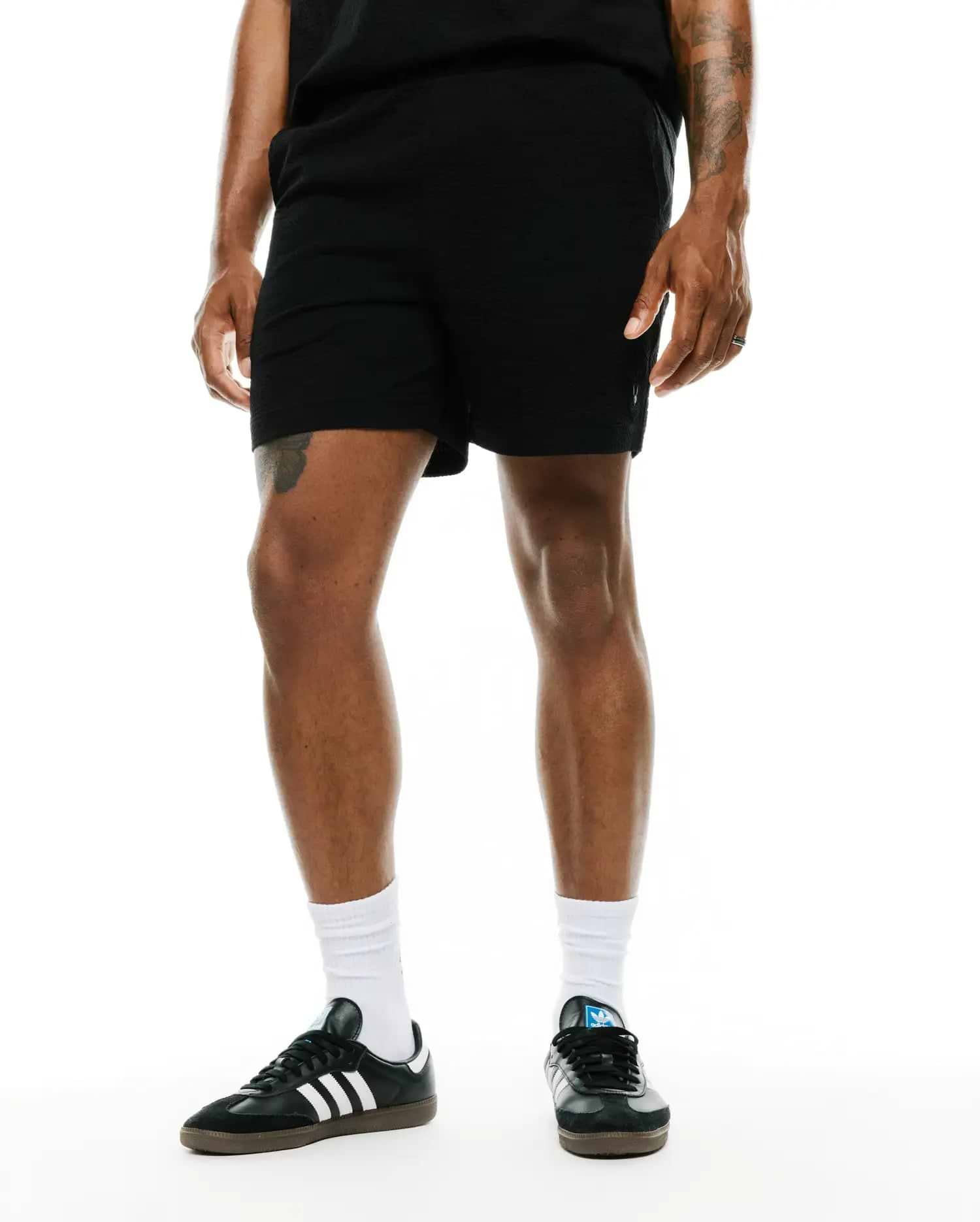 Mens Arlen Seersucker Short in black, featuring a relaxed fit and distinct seersucker texture, with a small embroidered Psycho Bunny skull logo on the lower left leg.
