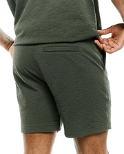 Mens Arlen Seersucker Short in dark olive green, featuring a classic fit, distinctive puckered seersucker texture, a subtle back welt pocket, and practical side pockets. (2)