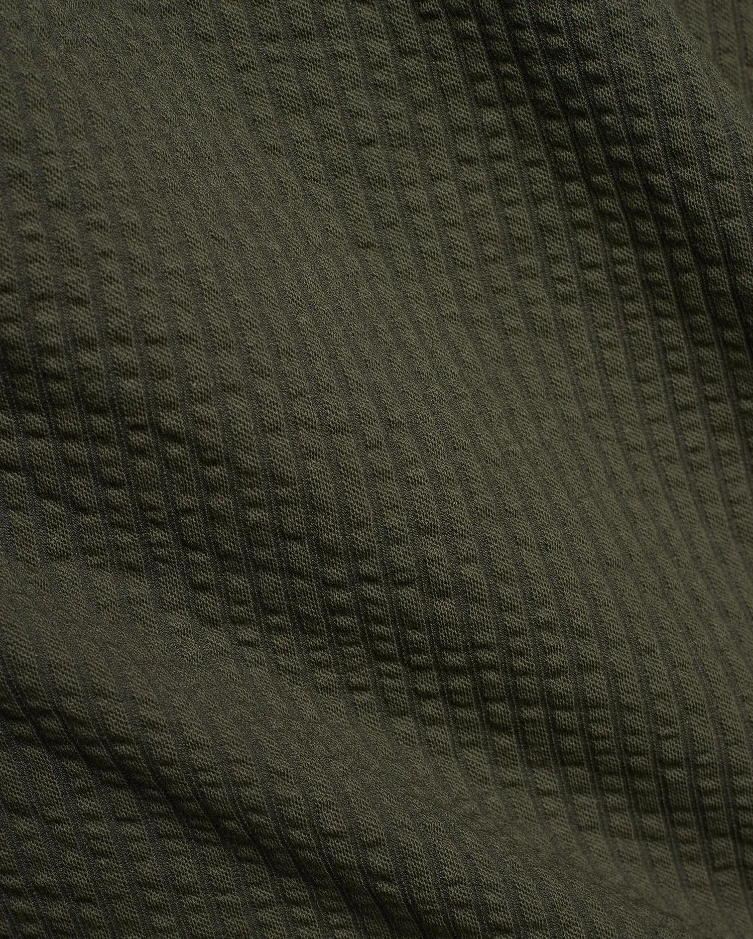 Psycho Bunny Mens Arlen Seersucker Short in dark olive green, featuring a classic seersucker fabric with a distinct puckered, vertically striped texture. (6)