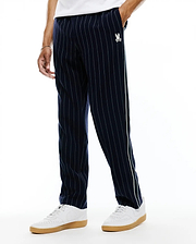 Harland Double Weave Chalk Stripe Track Pant in navy with white pinstripes, featuring a white and light green side stripe and a small embroidered white Psycho Bunny skull logo on the left thigh, classic fit. (2)