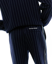 Mens Harland Double Weave Chalk Stripe Track Pant, navy with fine white pinstripes, a relaxed fit, and a prominent white side stripe. White embroidered PSYCHO BUNNY branding is on the back flap pocket. (4)
