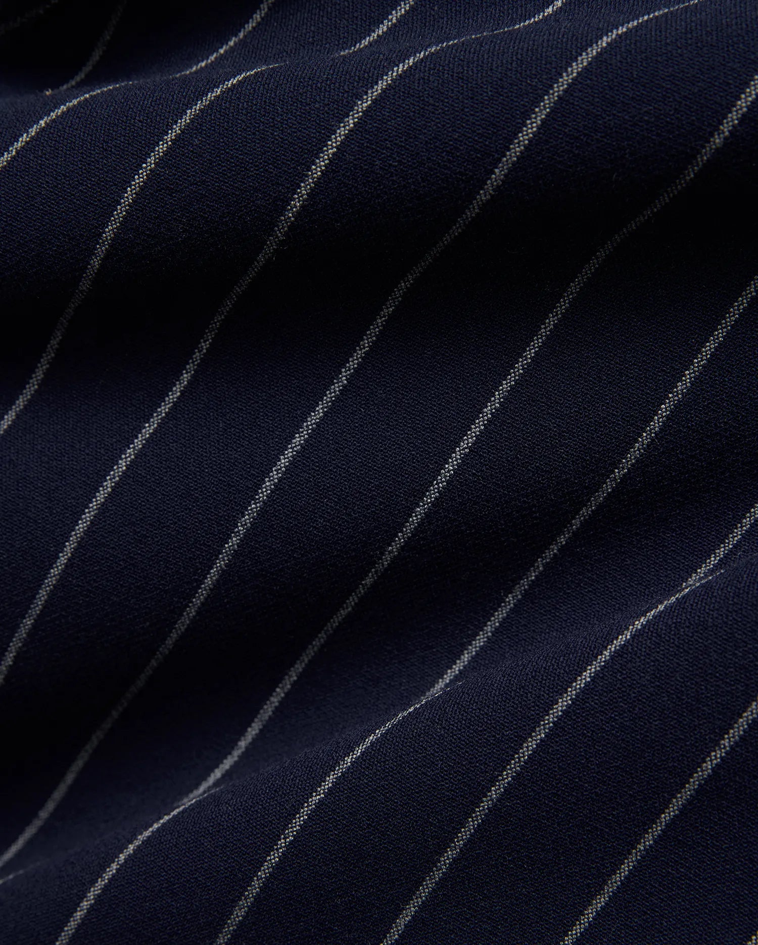 Mens Harland Double Weave Chalk Stripe Track Pant in deep navy blue, featuring fine, textured white chalk stripes woven into the fabric, highlighting its premium double weave texture. (6)