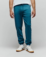 Mens Barry Joggers in deep teal, featuring a relaxed fit, soft jersey fabric, drawstring waist, ribbed cuffs, and a small tonal embroidered Psycho Bunny skull logo on the left thigh.