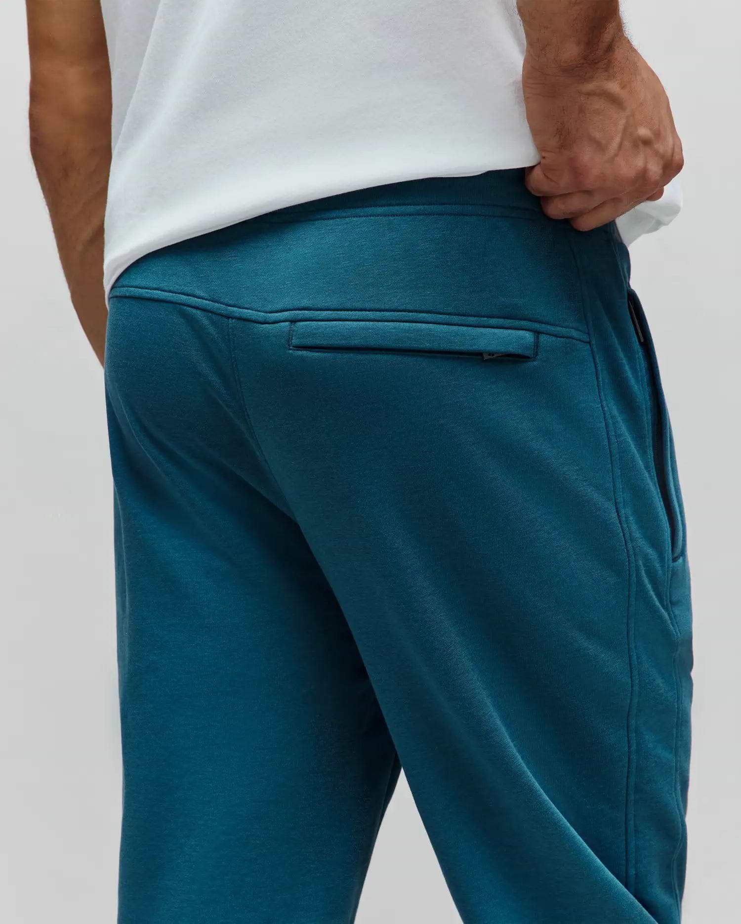 Mens Barry Joggers in deep teal, a relaxed fit, soft french terry knit, featuring a subtle rear zippered pocket and practical side pockets for refined streetwear style.
