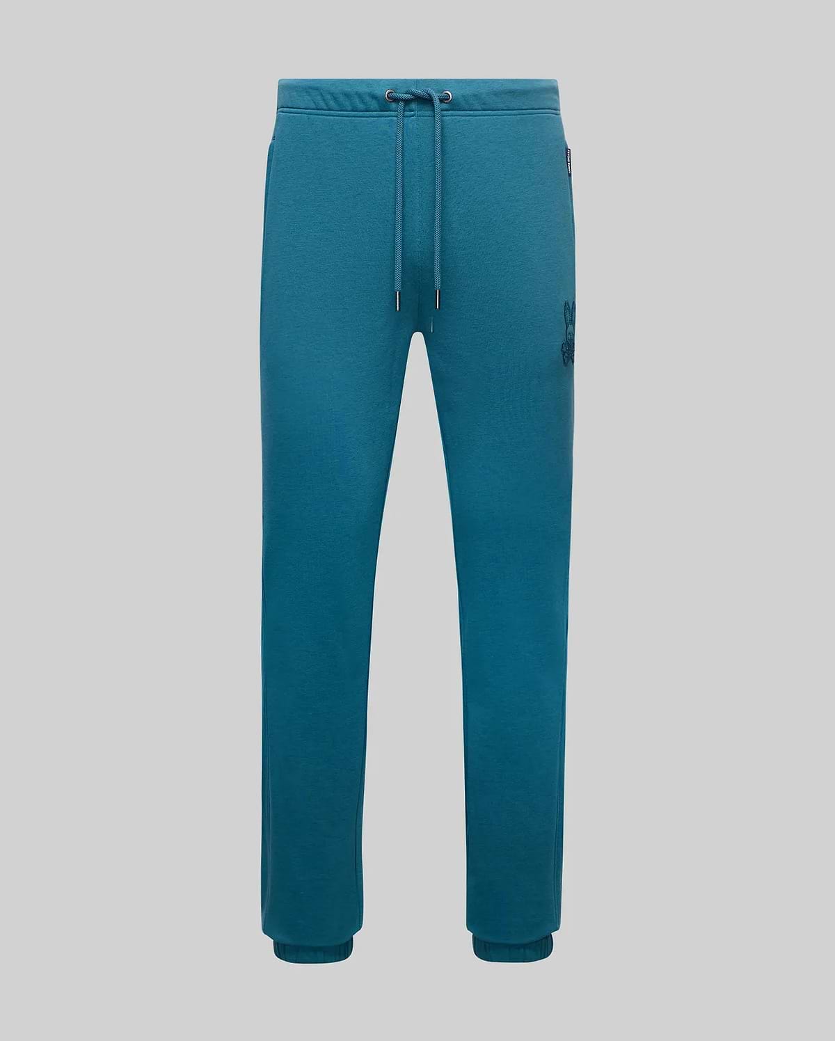 Mens Barry Joggers in teal french terry, featuring a relaxed fit, drawstring waist, ribbed cuffs, and a medium-sized embroidered dark teal Psycho Bunny skull logo on the right thigh.