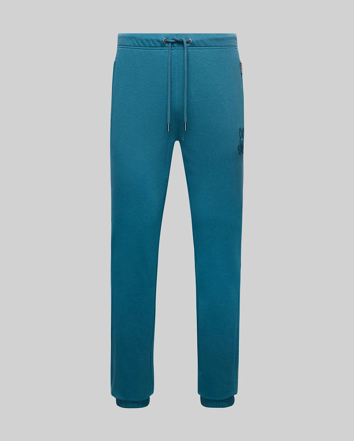 Mens Barry Joggers in teal french terry, featuring a relaxed fit, drawstring waist, ribbed cuffs, and a medium-sized embroidered dark teal Psycho Bunny skull logo on the right thigh.