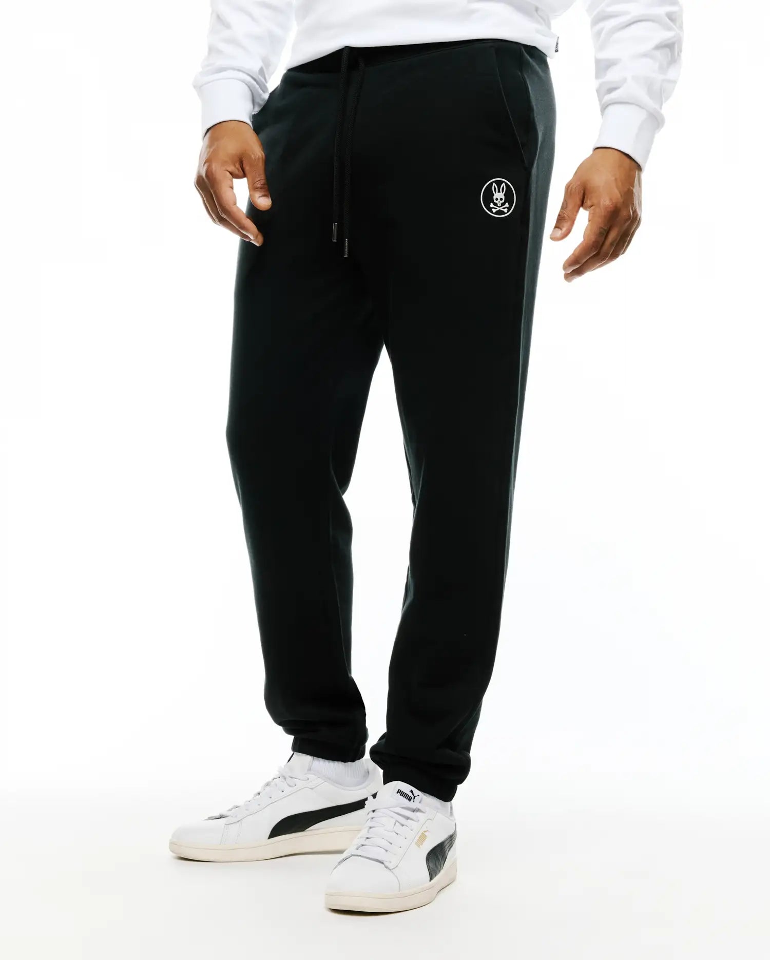 Mens Nathaniel Sweatpant, black relaxed fit french terry sweatpants with a drawstring waist, ribbed cuffs, and a small white embroidered Psycho Bunny skull logo on the left thigh.