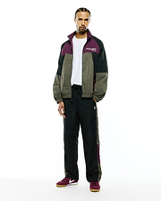 Relaxed crinkled nylon colorblock jacket in green, black, and purple with a white chest Psycho Bunny logo, matching Mens Alder Nylon Colorblock Pant with side panels and a small bunny skull.