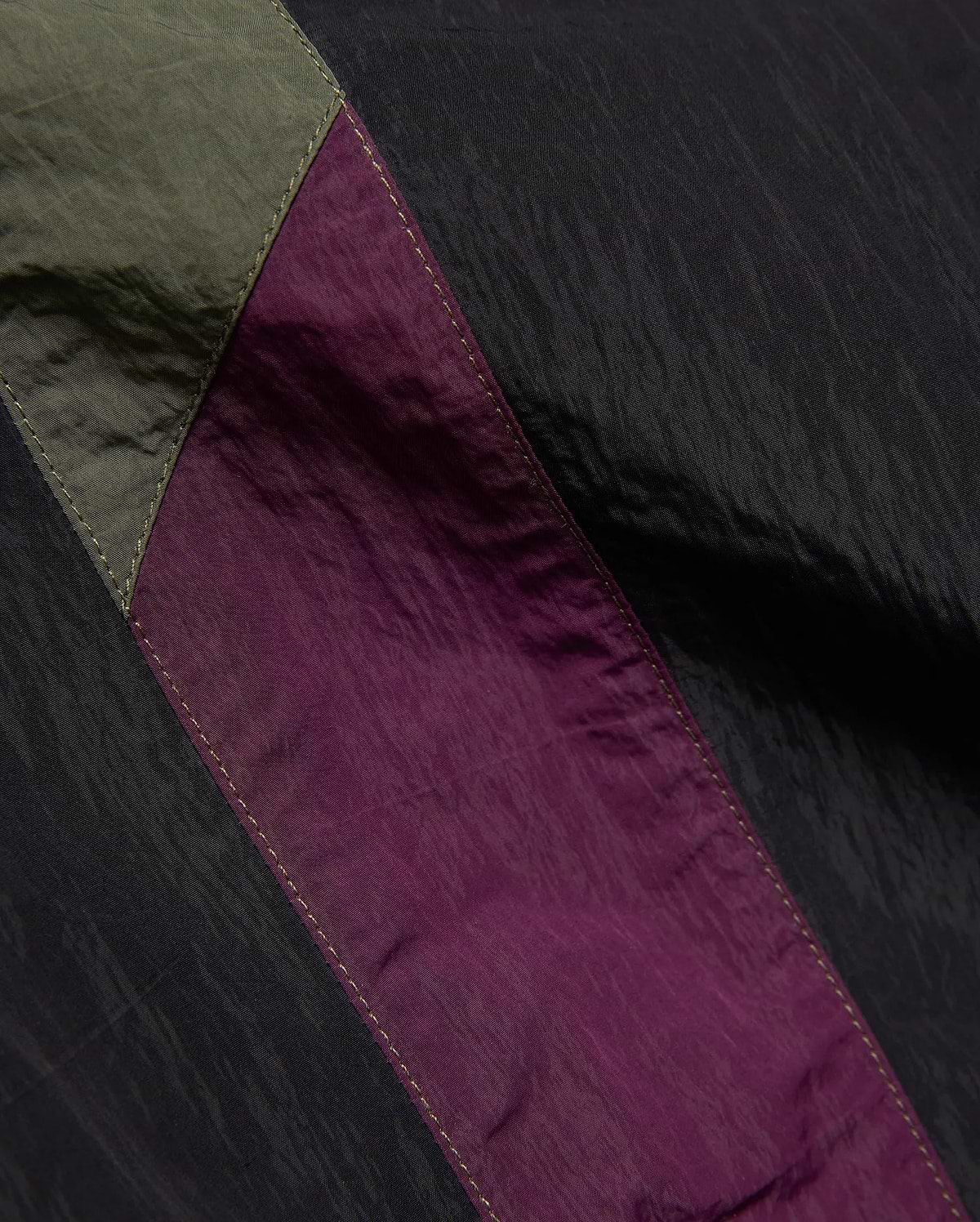 Mens Alder Nylon Colorblock Pant featuring crinkled black nylon with olive green and deep purple colorblock panels, accented by visible light stitching.