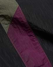 Mens Alder Nylon Colorblock Pant featuring crinkled black nylon with olive green and deep purple colorblock panels, accented by visible light stitching.