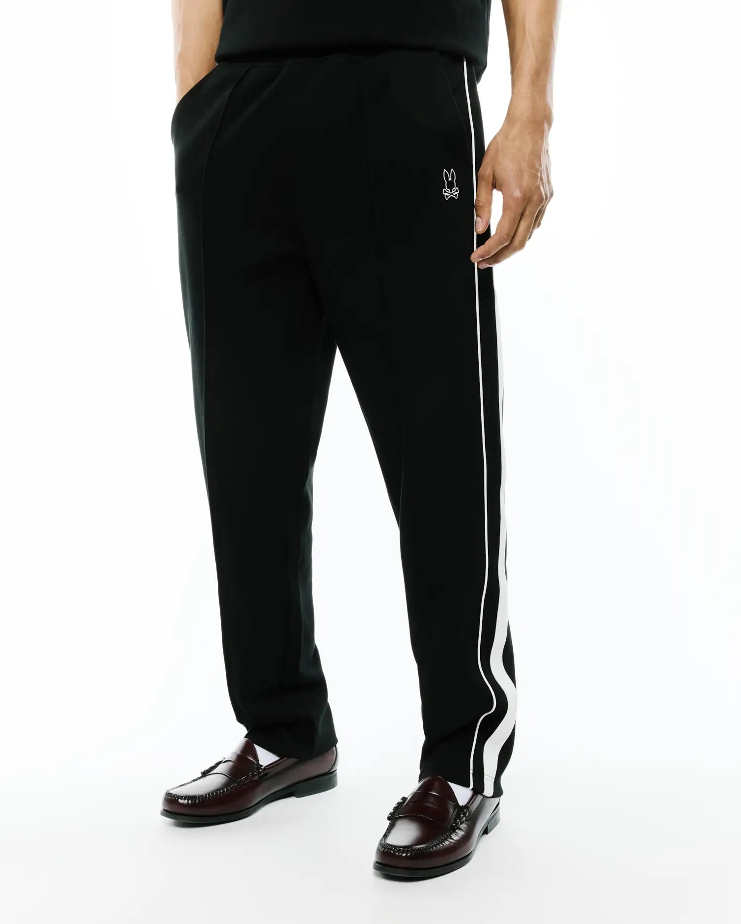Black Mens Ceano Track Pant, relaxed fit, smooth knit, with a distinctive white wavy side stripe and a small embroidered white Psycho Bunny skull logo on the left hip. (4)