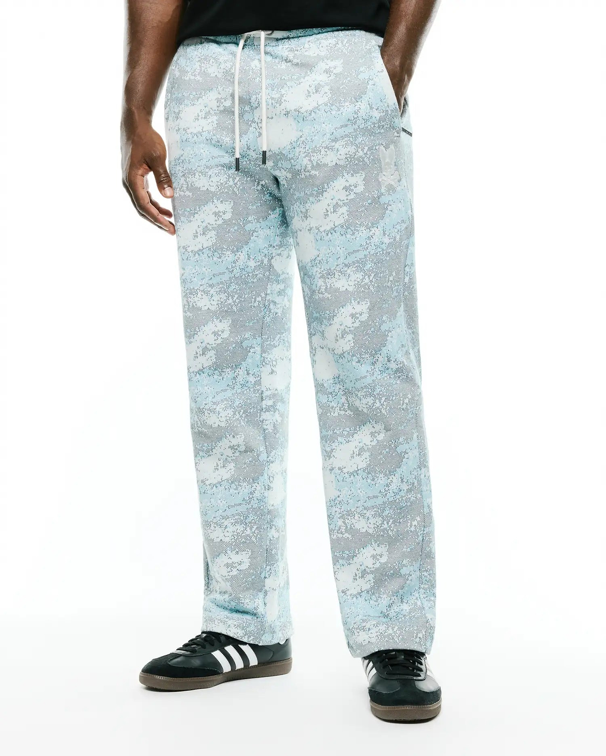 Men's Alfie Graphic Sweatpants in light blue, grey, and white digital camouflage pattern, featuring a relaxed straight leg fit, white drawstring, and small embroidered Psycho Bunny skull logo on the left thigh. (2)