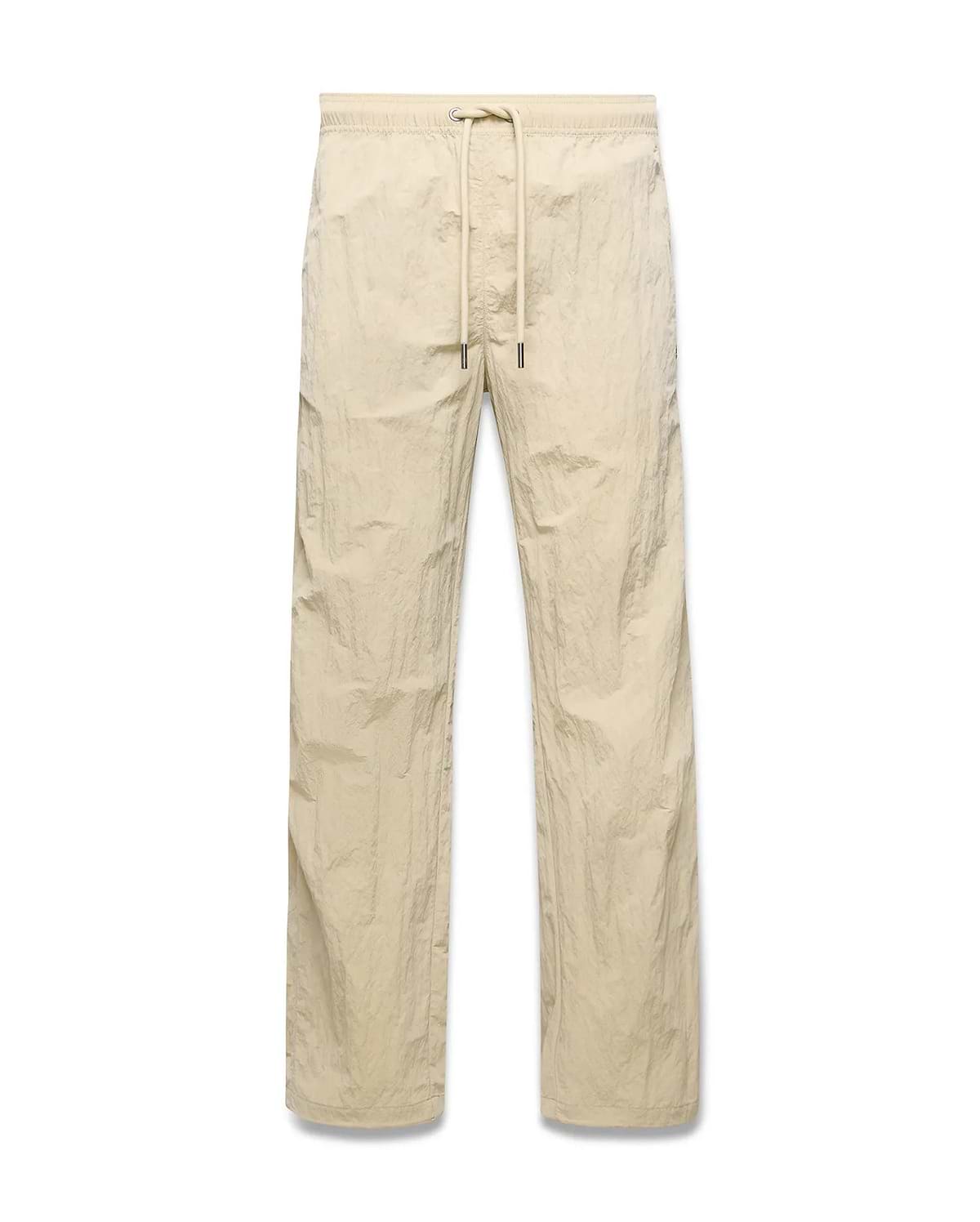 Mens Alder Nylon Pant in light beige with a crinkled nylon texture, featuring a relaxed straight-leg fit and an elasticated drawstring waist.