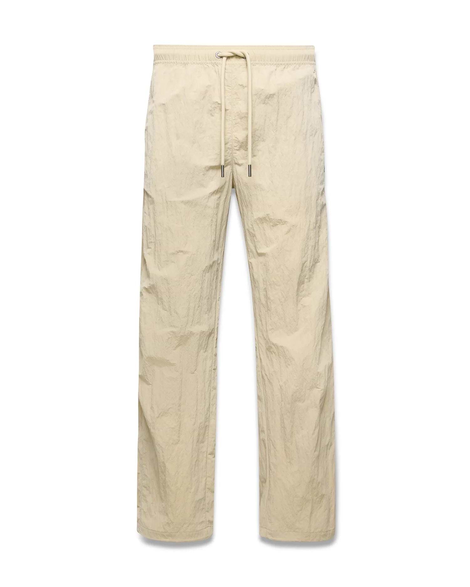 Mens Alder Nylon Pant in light beige with a crinkled nylon texture, featuring a relaxed straight-leg fit and an elasticated drawstring waist.
