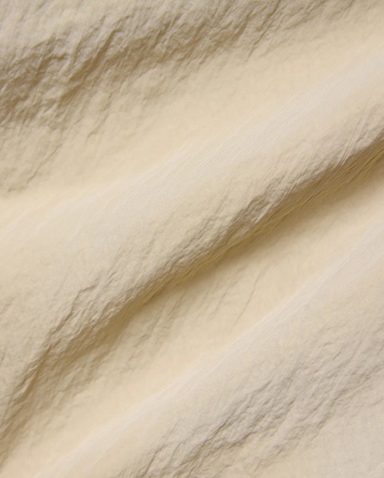 Mens Alder Nylon Pant in a sophisticated light beige hue, showcasing its premium, subtly textured and crinkled nylon fabric with a refined, fine weave, ideal for refined streetwear.