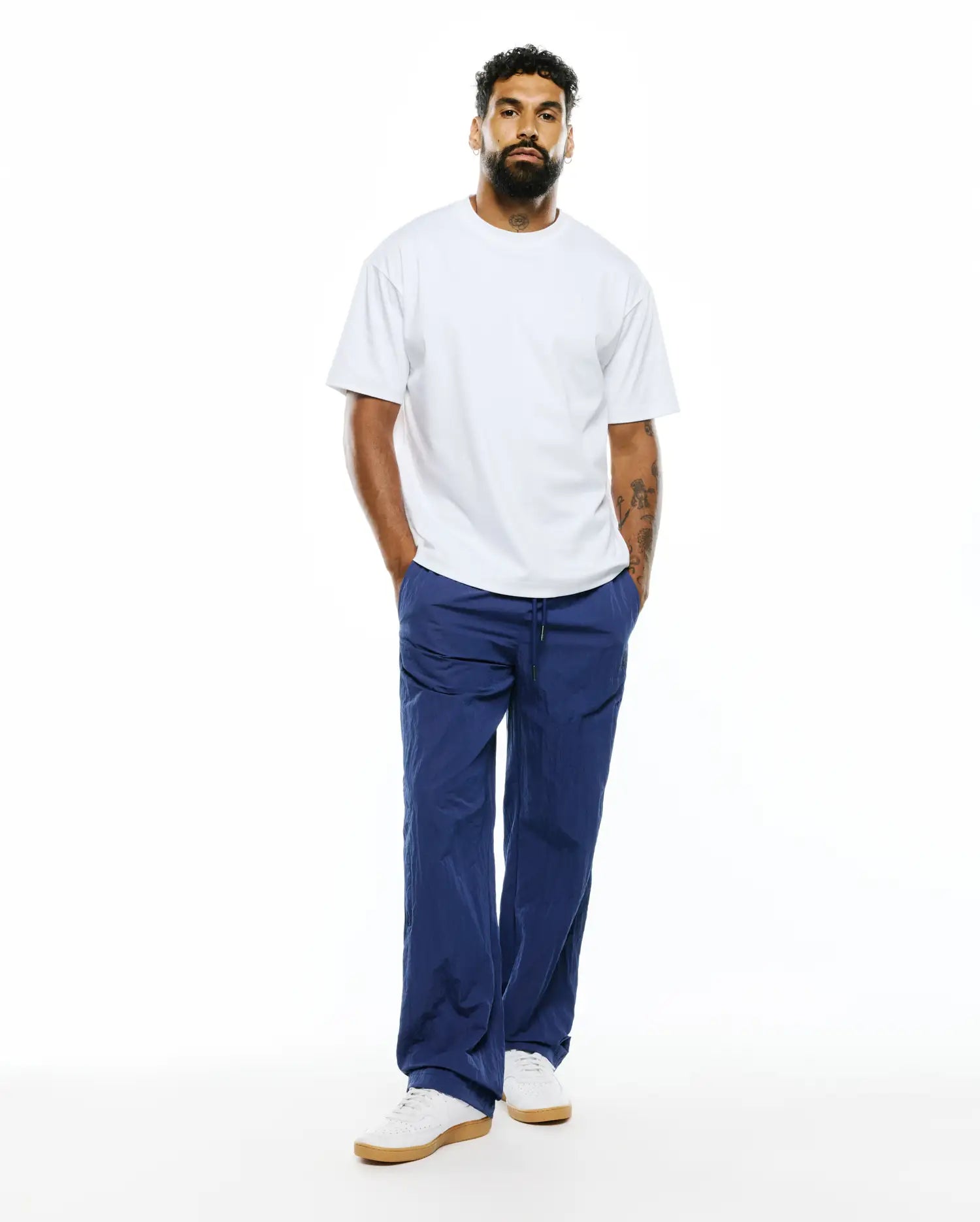 Relaxed fit white jersey t-shirt paired with MENS ALDER NYLON PANT in deep blue, featuring a crinkled texture, drawstring waist, and a comfortable, refined streetwear aesthetic. (4)