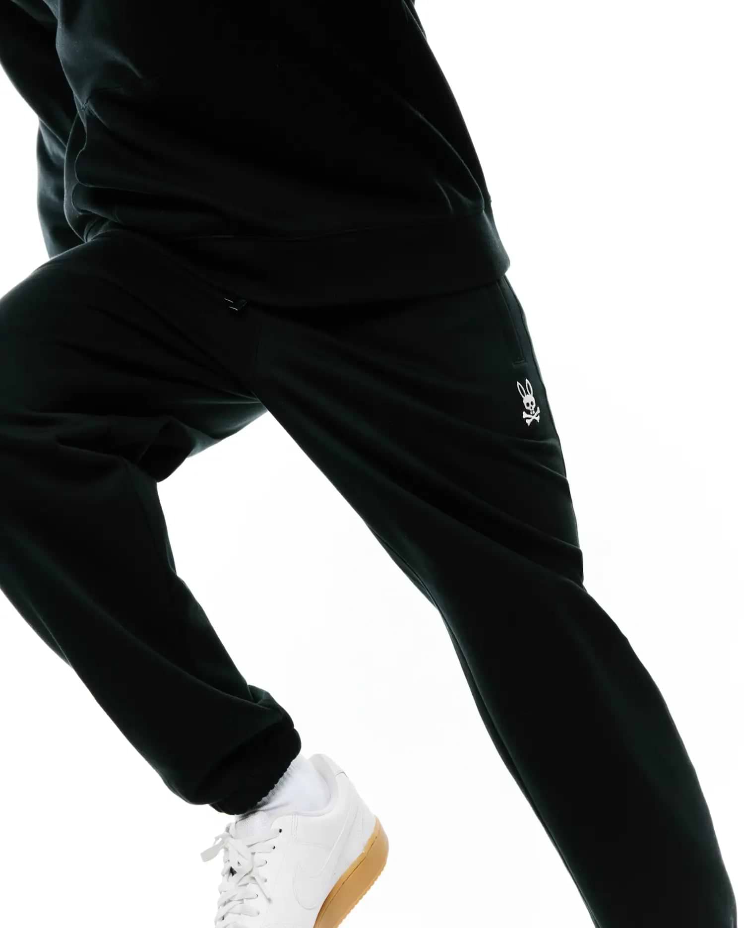 MENS TERRENCE BRUSHED FLEECE SWEATPANT in black, featuring a relaxed fit, cuffed ankles, and a small, white embroidered Psycho Bunny skull logo on the left thigh.