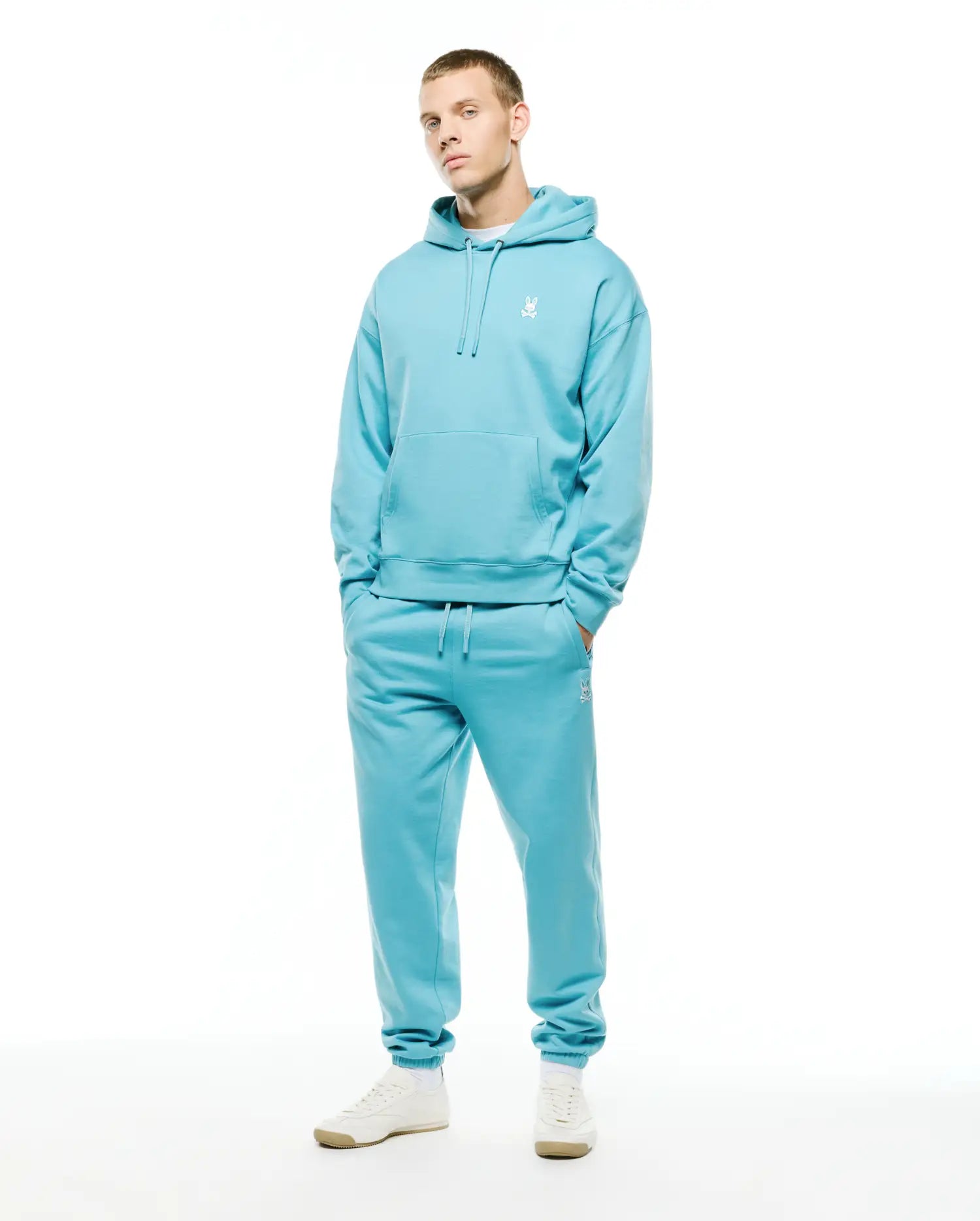Aqua blue relaxed fit brushed fleece hoodie with white embroidered Psycho Bunny skull logo on left chest, paired with matching Mens Terrence Brushed Fleece Jogger featuring a white logo on the left thigh. (1)
