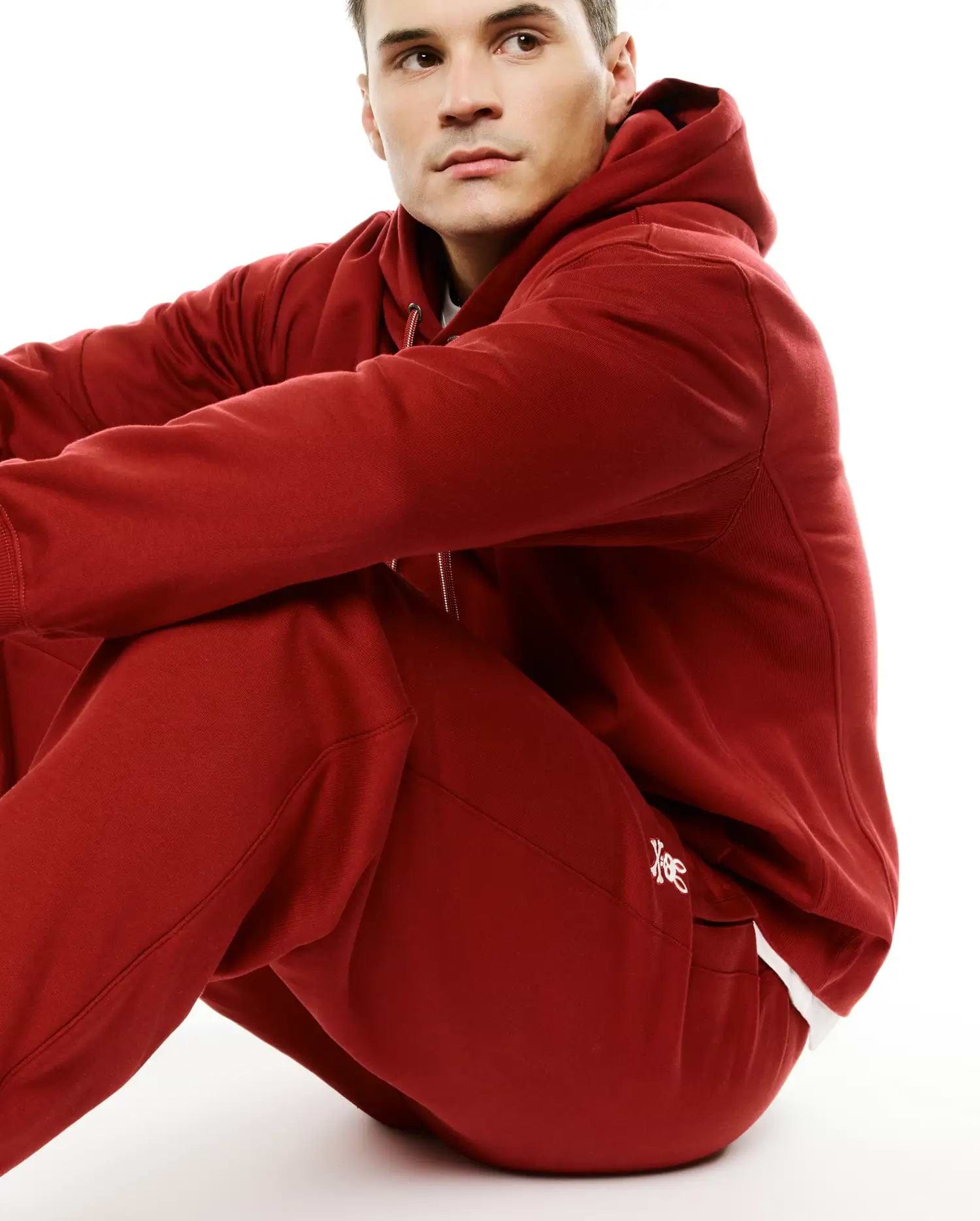 Deep red Mens Terrence Brushed Fleece Jogger and matching relaxed fit full-zip hoodie, both with ribbed cuffs. White embroidered Psycho Bunny skull logo on jogger's left thigh. (4)