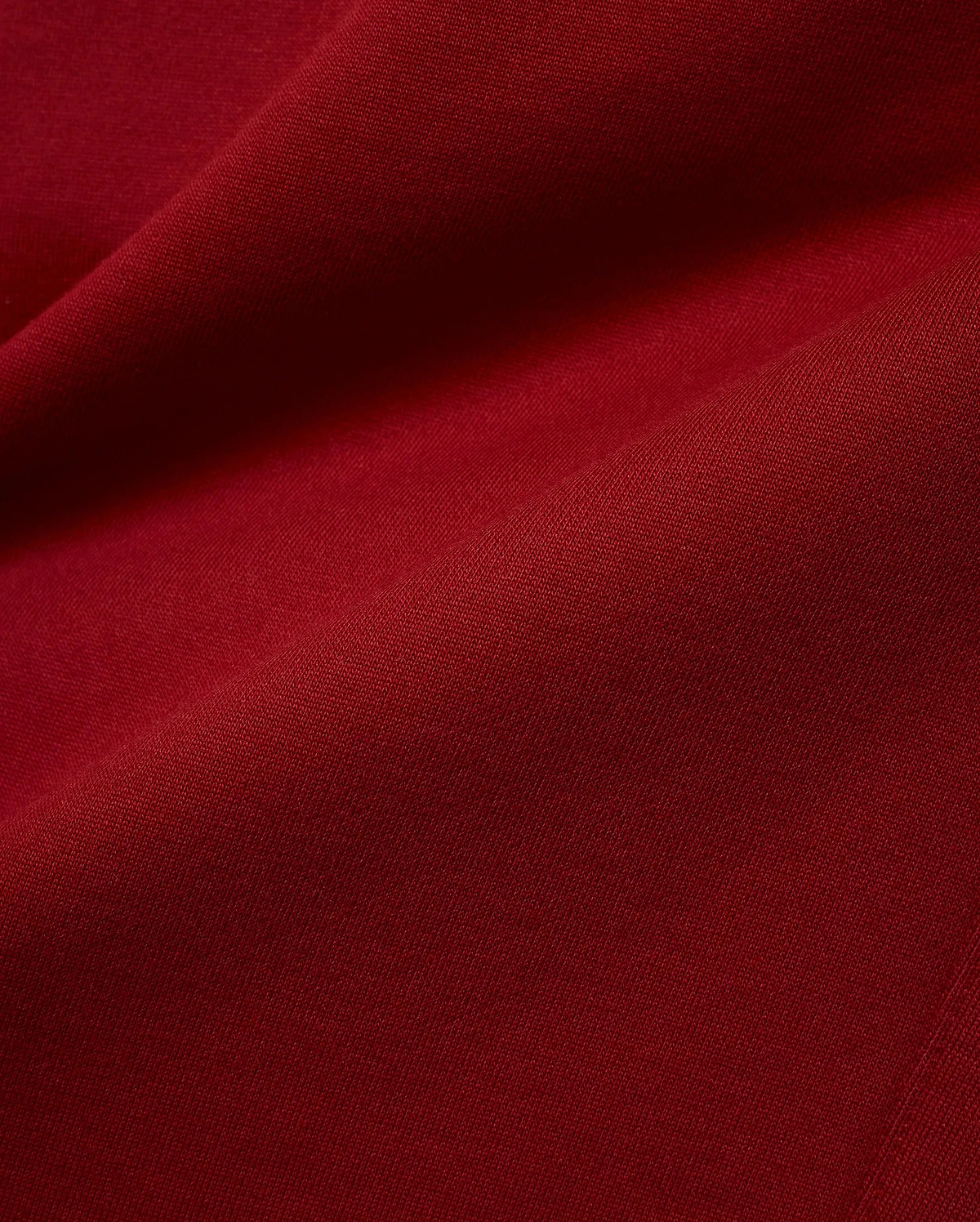Mens Terrence Brushed Fleece Jogger in a deep, luxurious burgundy red, a close-up revealing the soft, plush texture of the brushed fleece fabric with subtle diagonal knit details. (6)