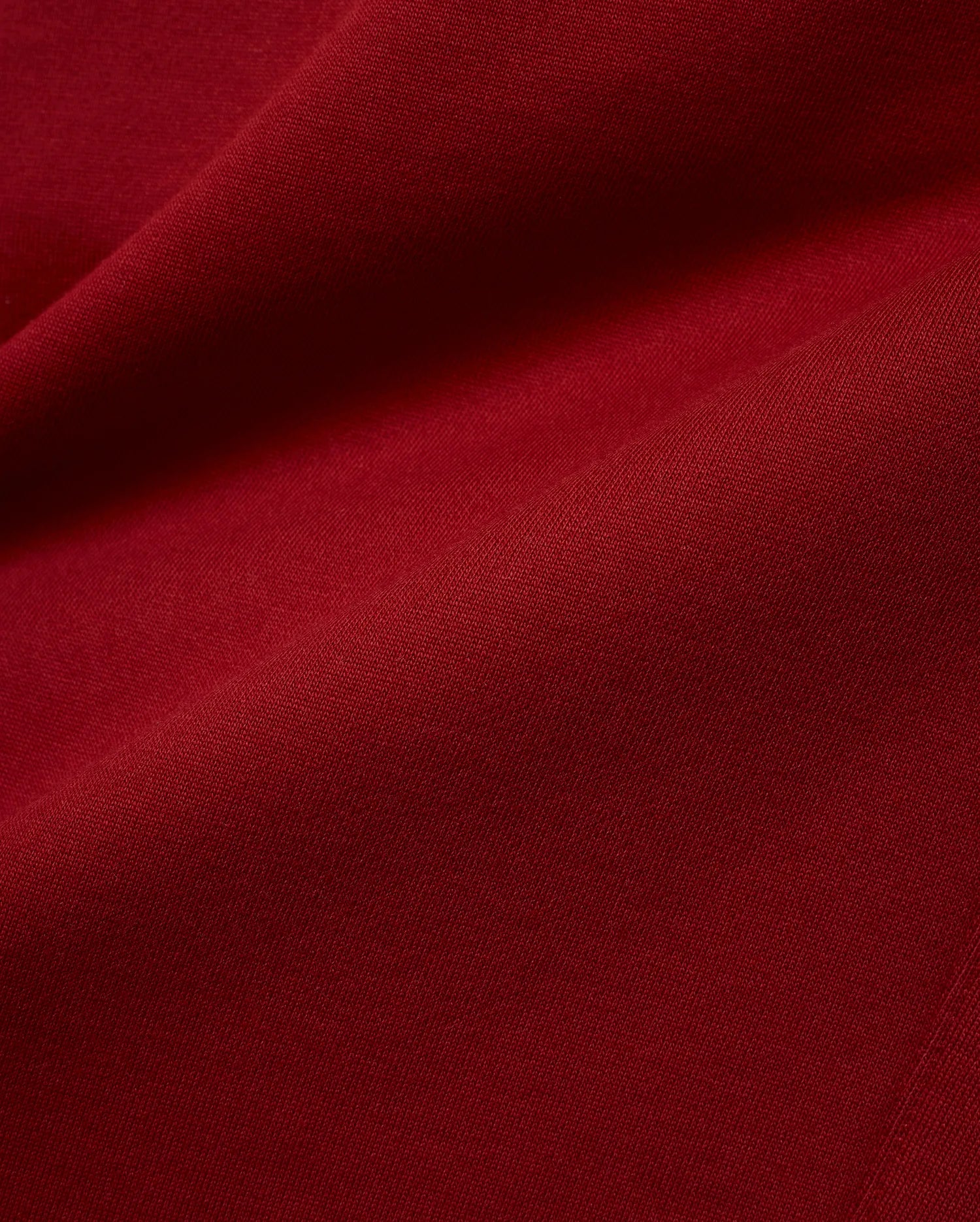 Mens Terrence Brushed Fleece Jogger in a deep, luxurious burgundy red, a close-up revealing the soft, plush texture of the brushed fleece fabric with subtle diagonal knit details. (6)