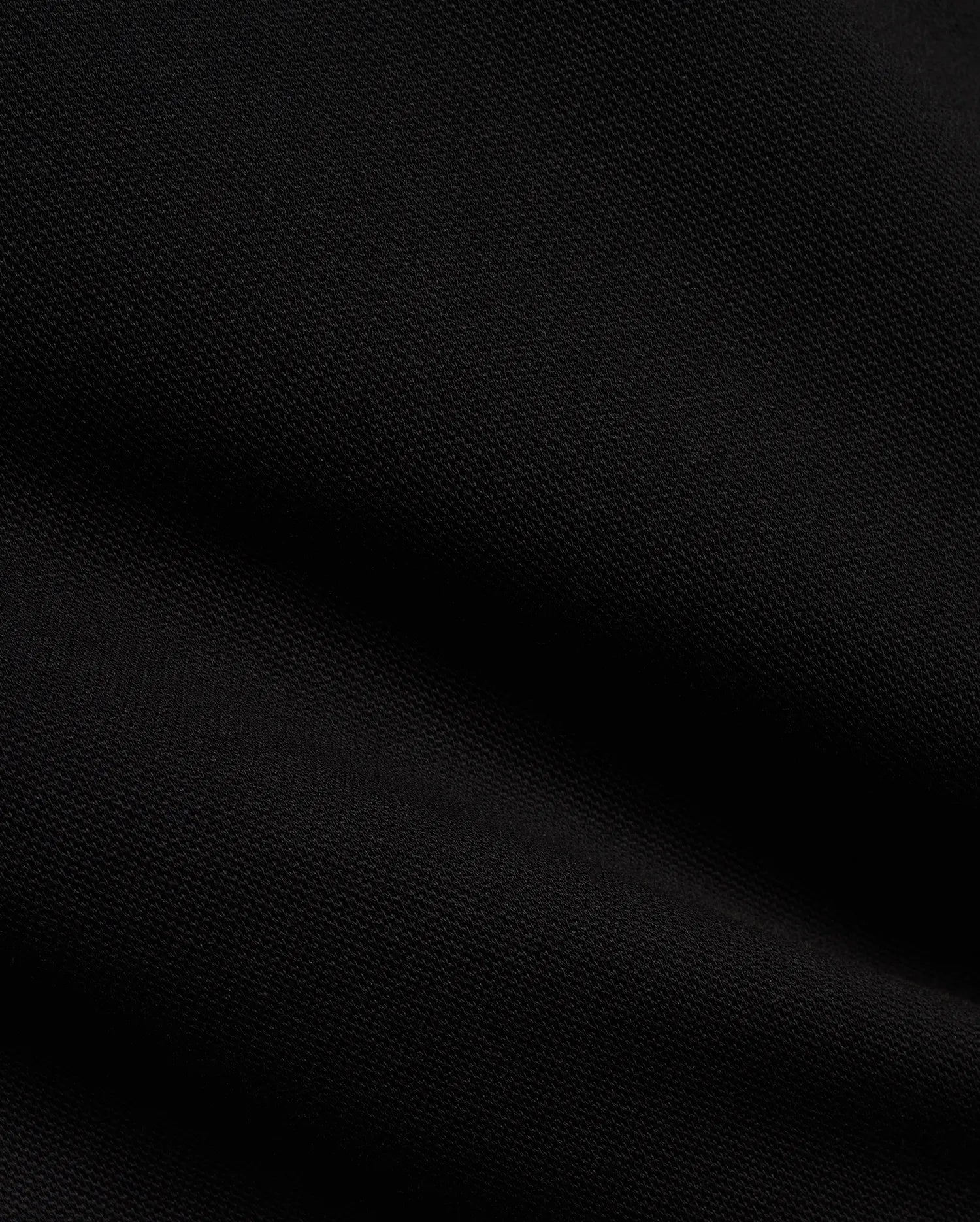 Men's Jacques Pique Track Pants in deep black, showcasing the refined, breathable pique knit fabric texture with subtle diagonal ribbing and soft folds, characteristic of premium Psycho Bunny streetwear. (6)