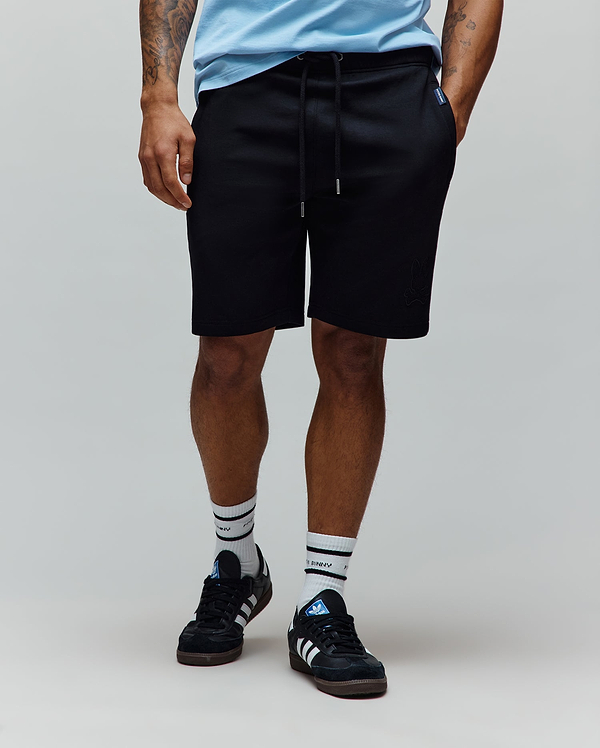 Black Mens Barry Short in relaxed fit french terry, featuring a drawstring waist, side pockets, a tonal embroidered bunny skull logo on the left leg, and a blue Psycho Bunny tag.