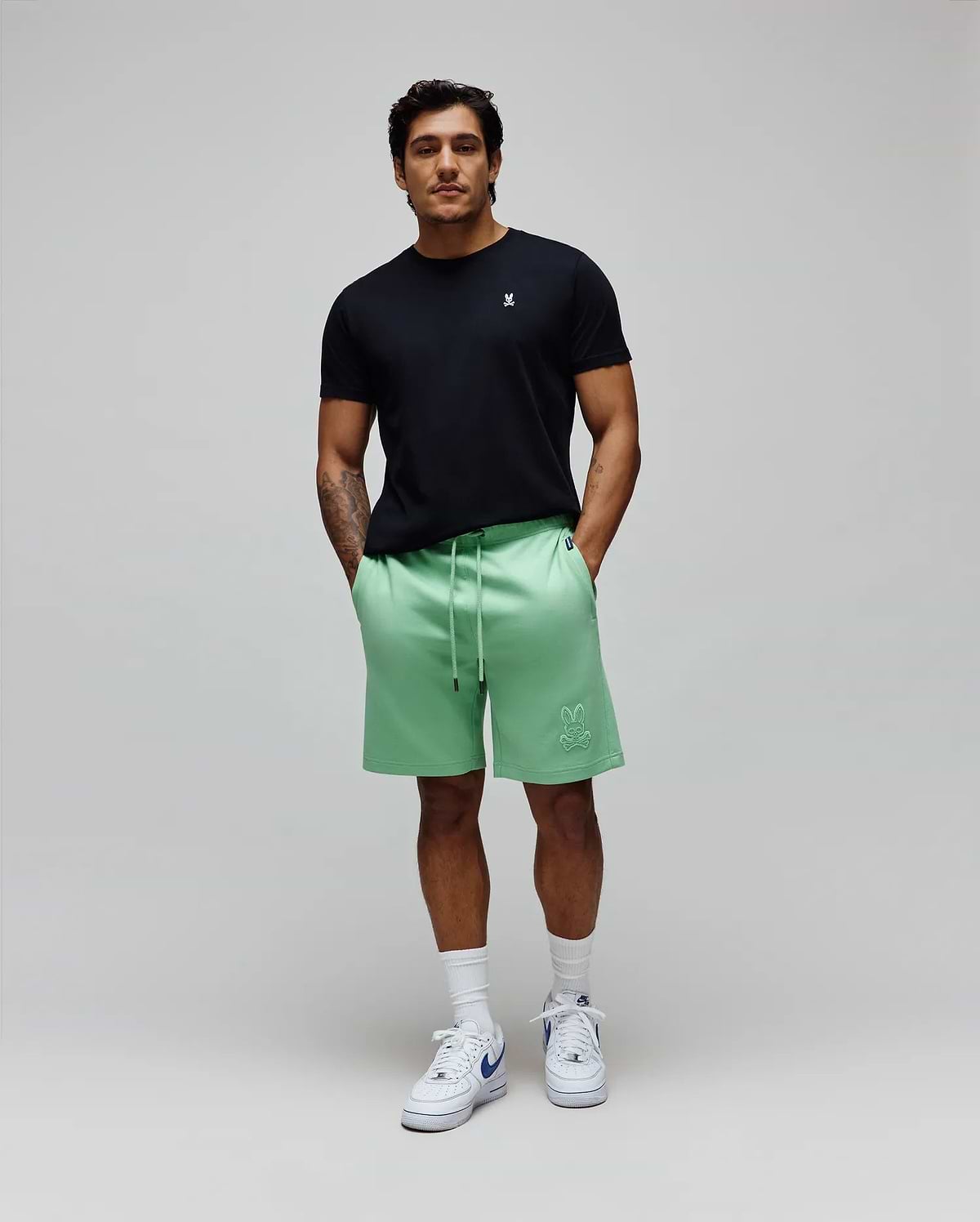 Black jersey t-shirt with small white embroidered Psycho Bunny logo on chest. Mens Barry Short, mint green french terry shorts featuring a large tonal embroidered bunny skull logo on the left thigh.