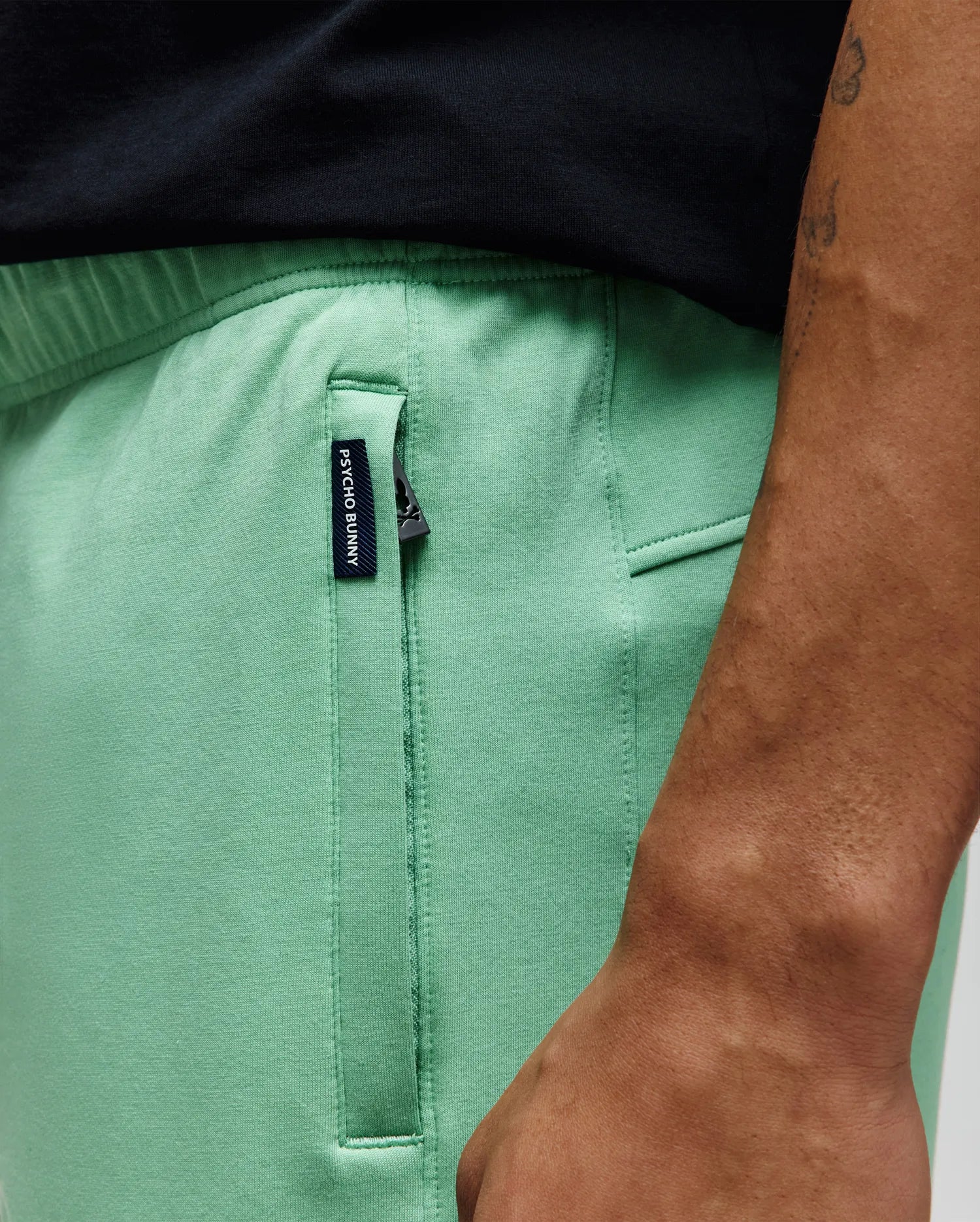 Mens Barry Short in mint green, featuring a relaxed fit, smooth jersey fabric, and a black zippered side pocket with a small woven Psycho Bunny tag.