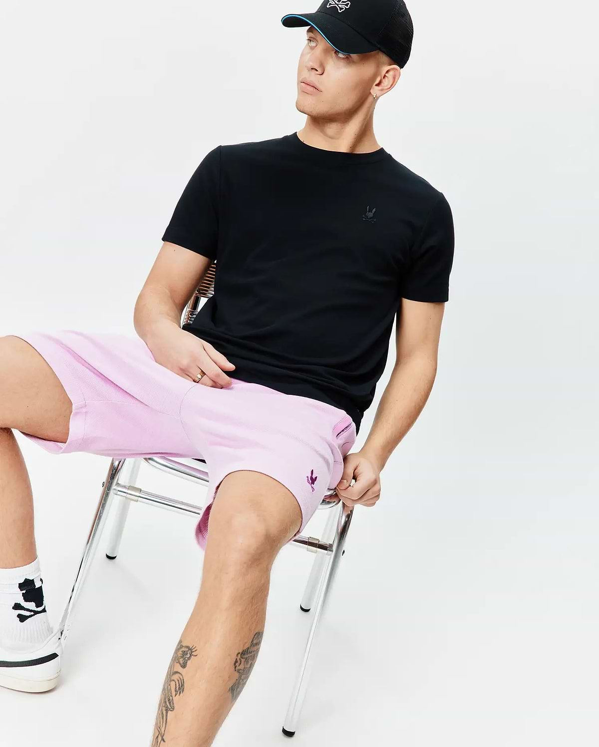 Black classic fit jersey t-shirt with tonal Psycho Bunny skull on chest; light pink Mens Keith Short 8 relaxed pique shorts with purple Psycho Bunny skull on thigh.