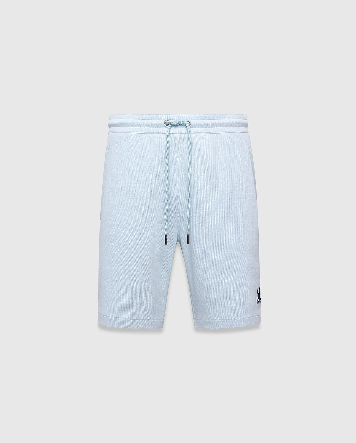 Mens Keith Short 8 light blue pique knit shorts, relaxed fit, featuring a drawstring waist with silver eyelets and dark blue tips, and a small embroidered dark blue Psycho Bunny skull logo on the lower left leg.