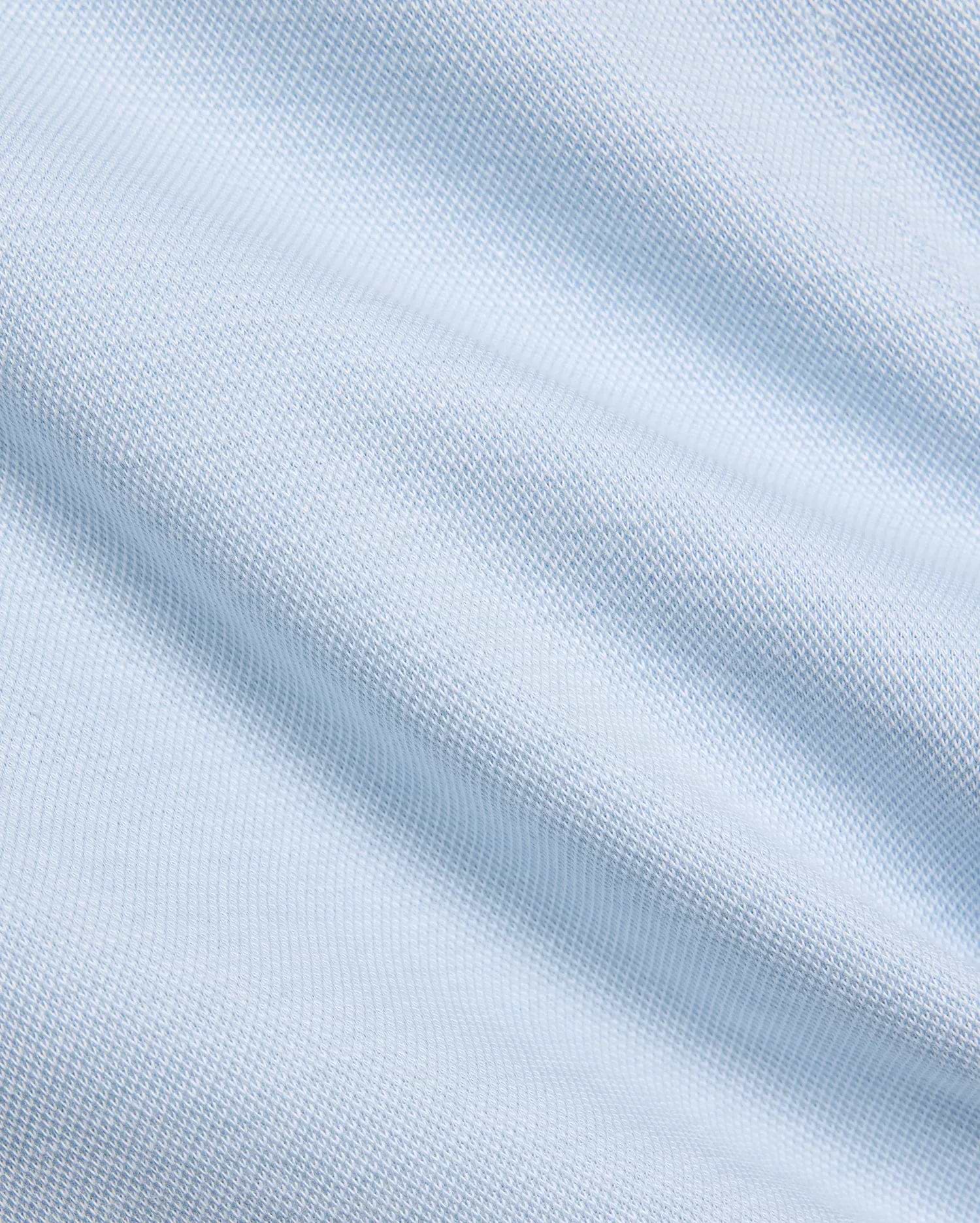 Mens Keith Short 8, showcasing a close-up of its premium light blue pique knit fabric, featuring a subtle, breathable texture, embodying Psycho Bunny's refined streetwear aesthetic.