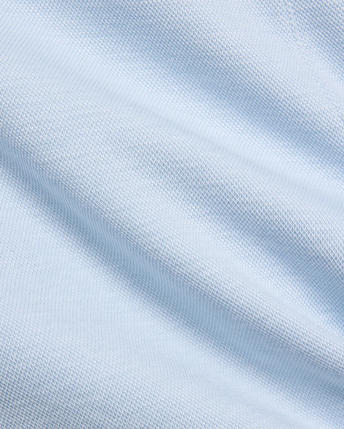 Mens Keith Short 8, showcasing a close-up of its premium light blue pique knit fabric, featuring a subtle, breathable texture, embodying Psycho Bunny's refined streetwear aesthetic.