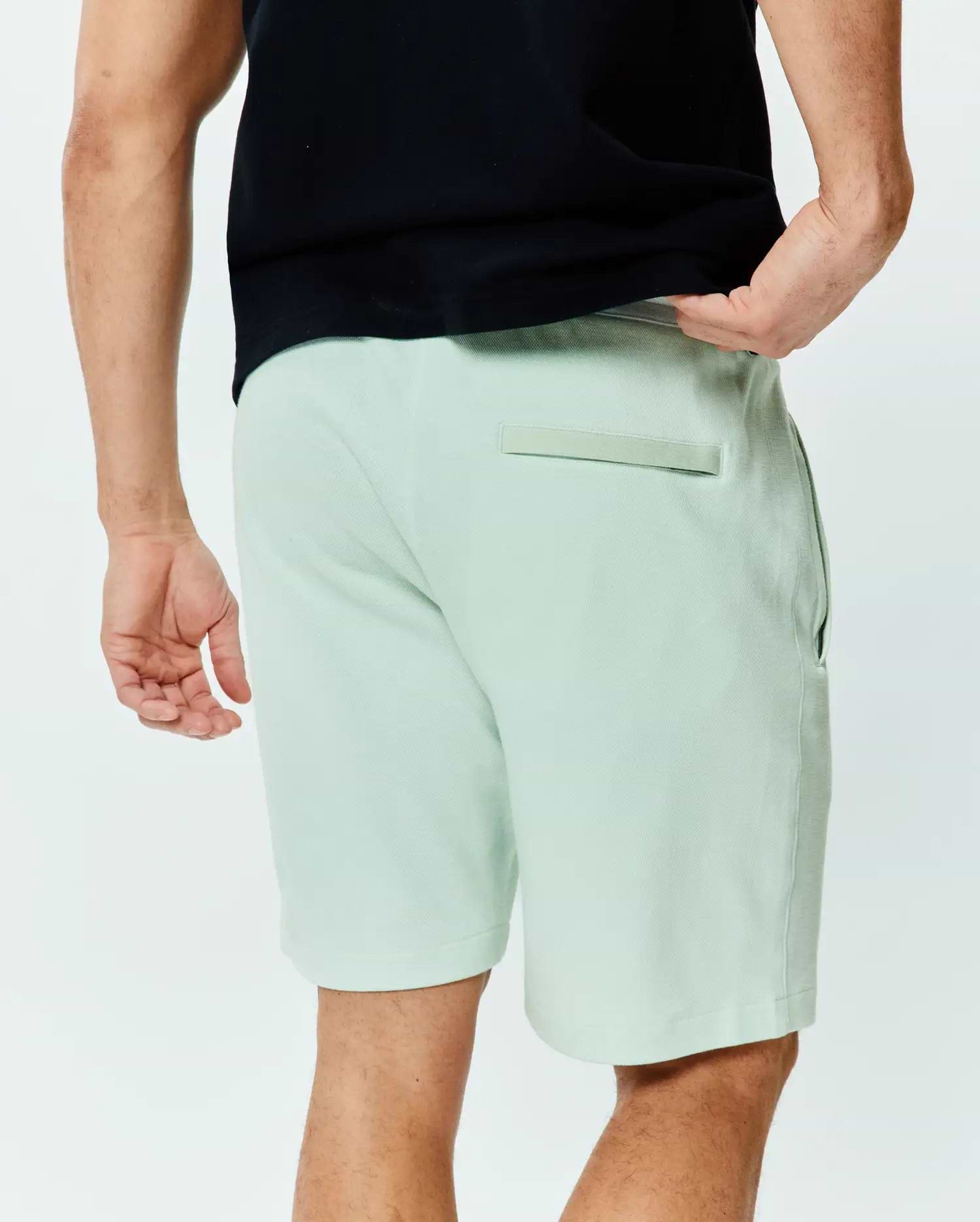 Mens Keith Short 8, light green pique knit shorts with a classic fit, featuring side pockets and a back welt pocket with a tonal fabric detail.