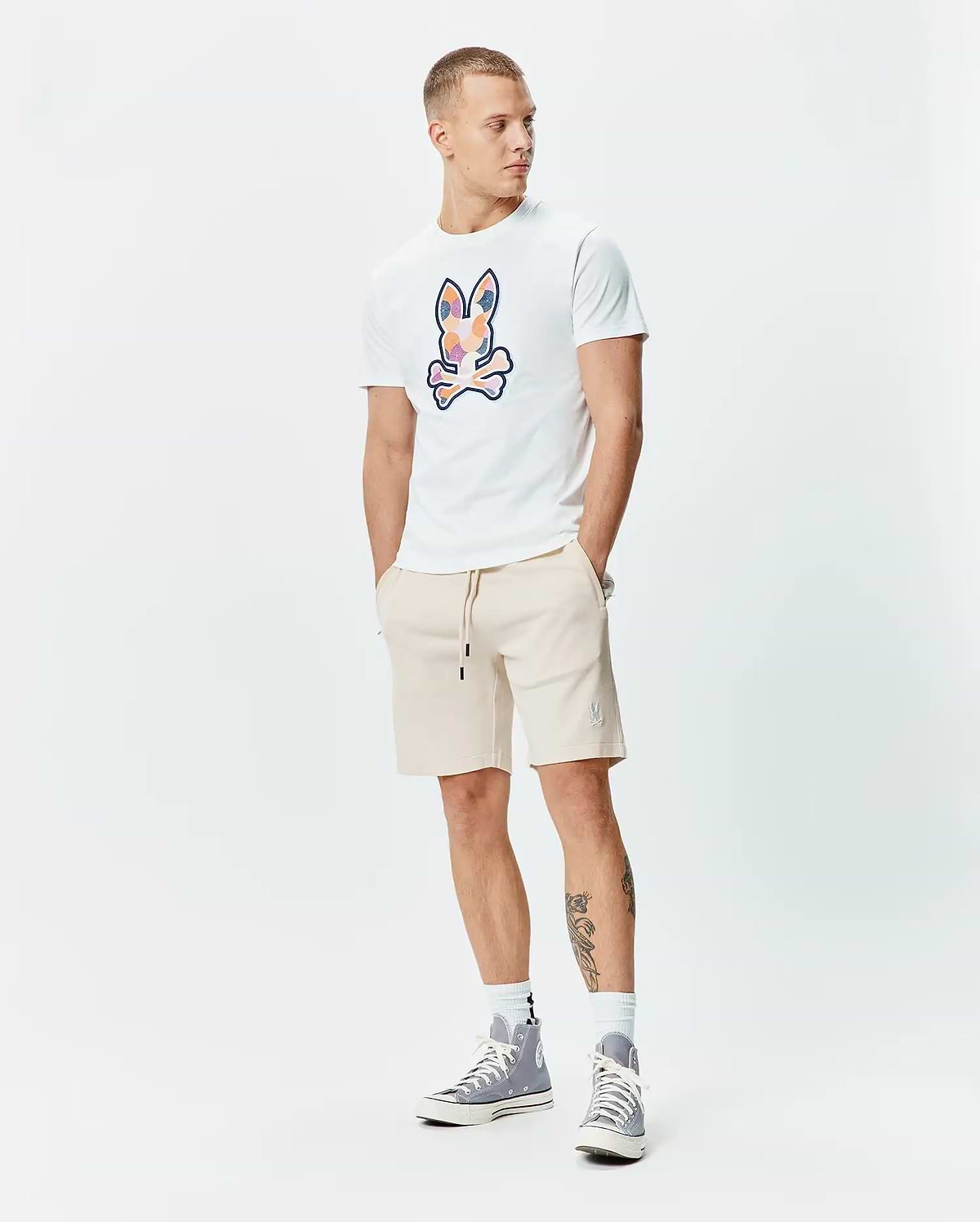 White classic fit jersey t-shirt with large multi-color graphic Psycho Bunny skull. Beige relaxed fit French terry Mens Keith Short 8 with small embroidered bunny logo and black drawstrings.
