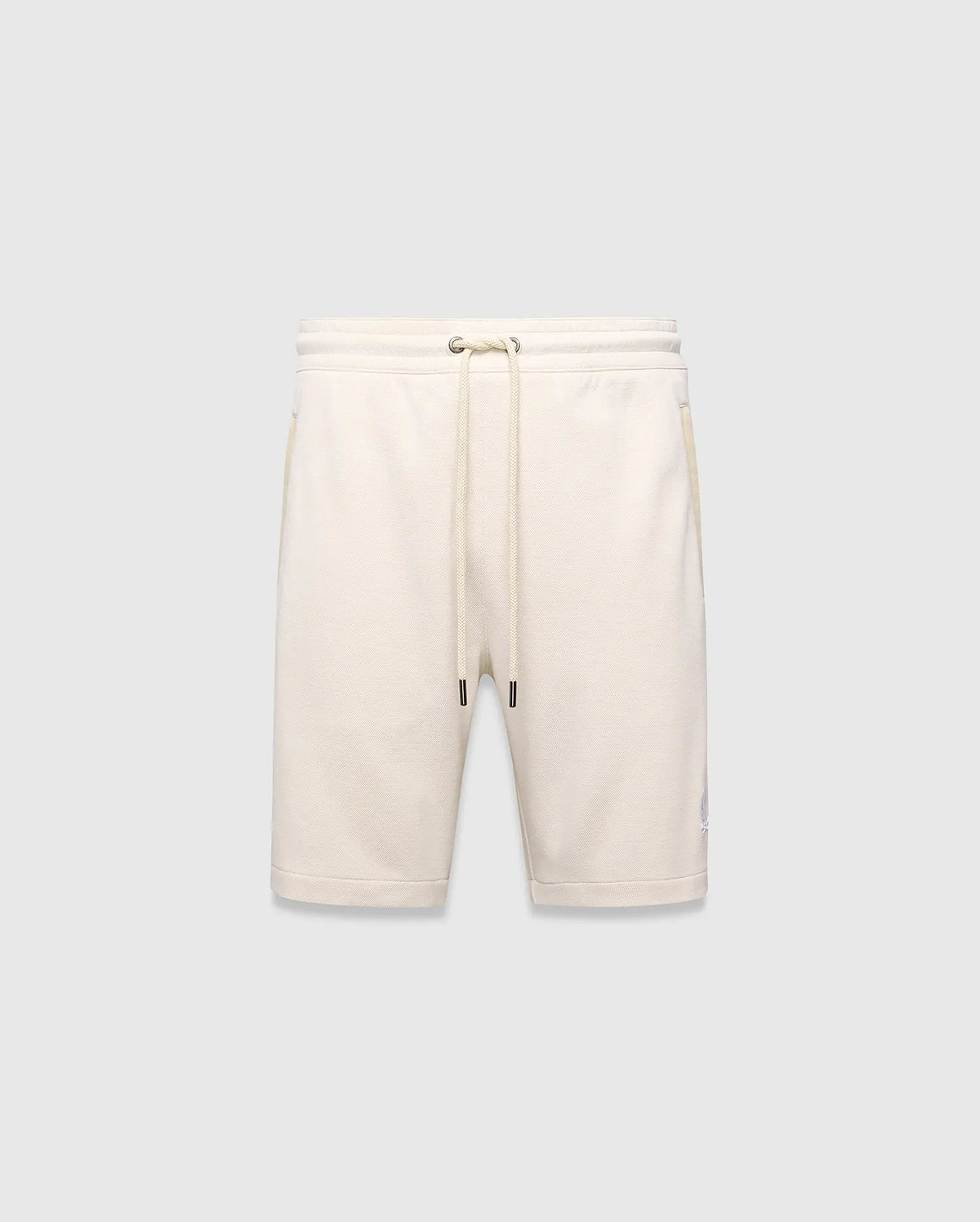 Mens Keith Short 8, cream pique knit shorts with a relaxed fit, featuring a drawstring waist, side pockets, and a small embroidered lavender Psycho Bunny skull logo on the left leg.
