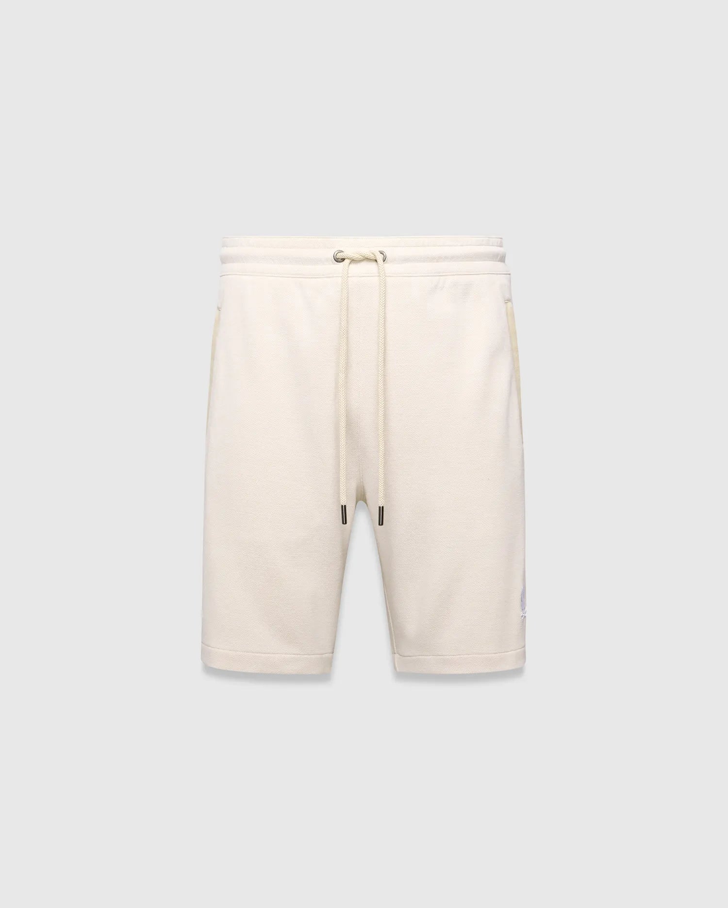 Mens Keith Short 8, cream pique knit shorts with a relaxed fit, featuring a drawstring waist, side pockets, and a small embroidered lavender Psycho Bunny skull logo on the left leg.
