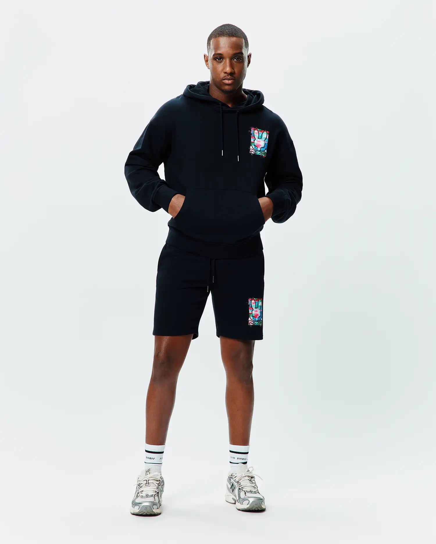 Black relaxed fit French terry hoodie with a large colorful abstract bunny skull graphic on the left chest, paired with matching Mens Isaac Print Short with the same graphic on the left thigh.